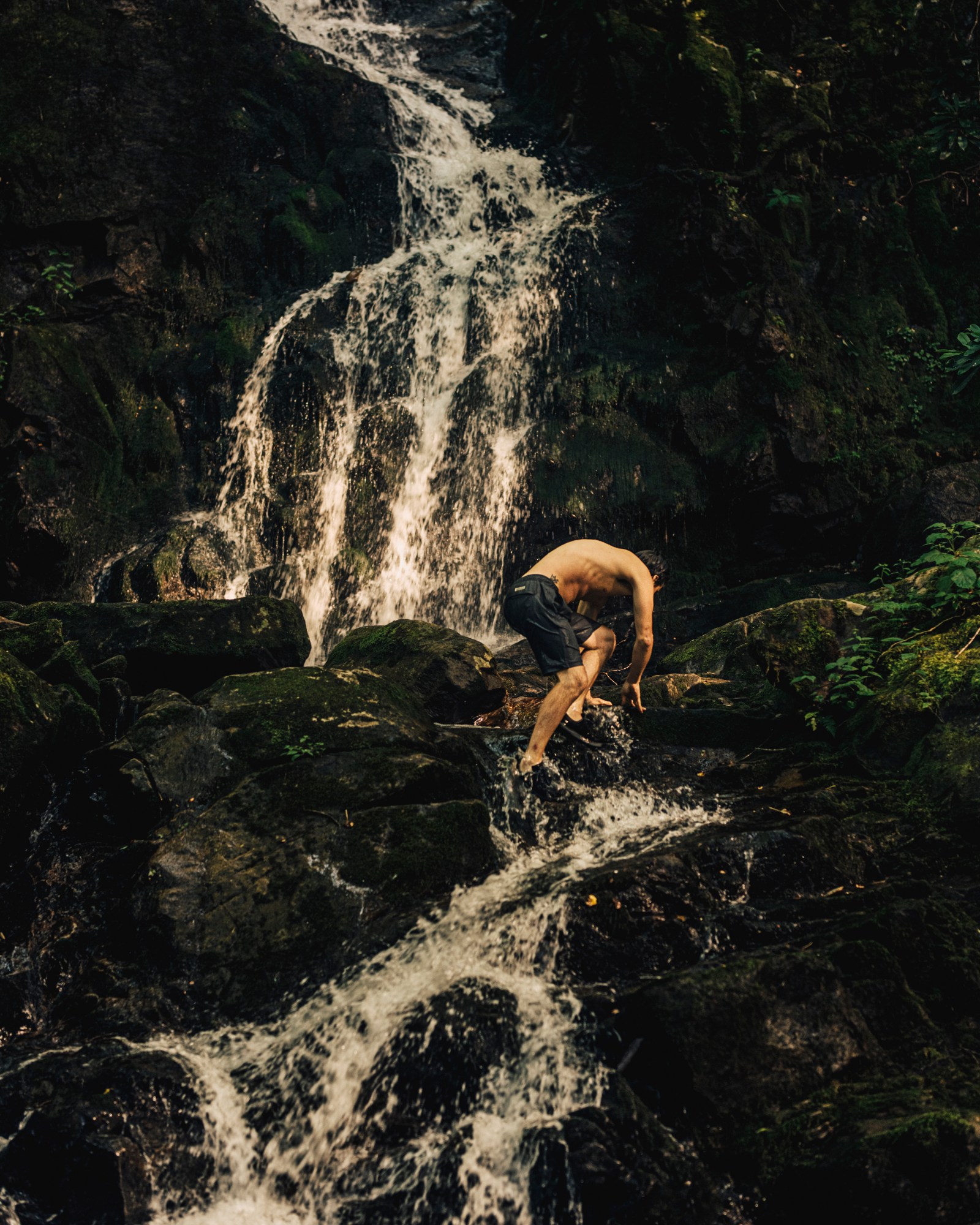 A man climbing a rocky waterfall