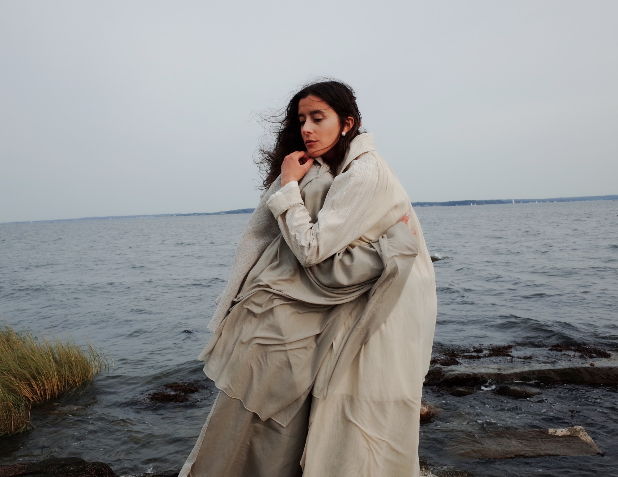 two models hugging by the sea in coats by bingjin zhu