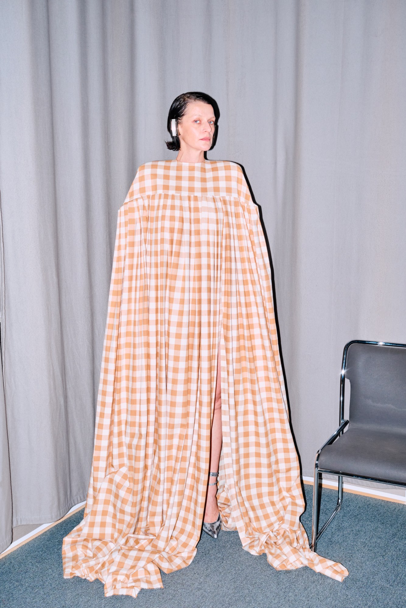 model wearing an oversized cape-like yellow and white gingham dress by Ellen Hodakova Larsson