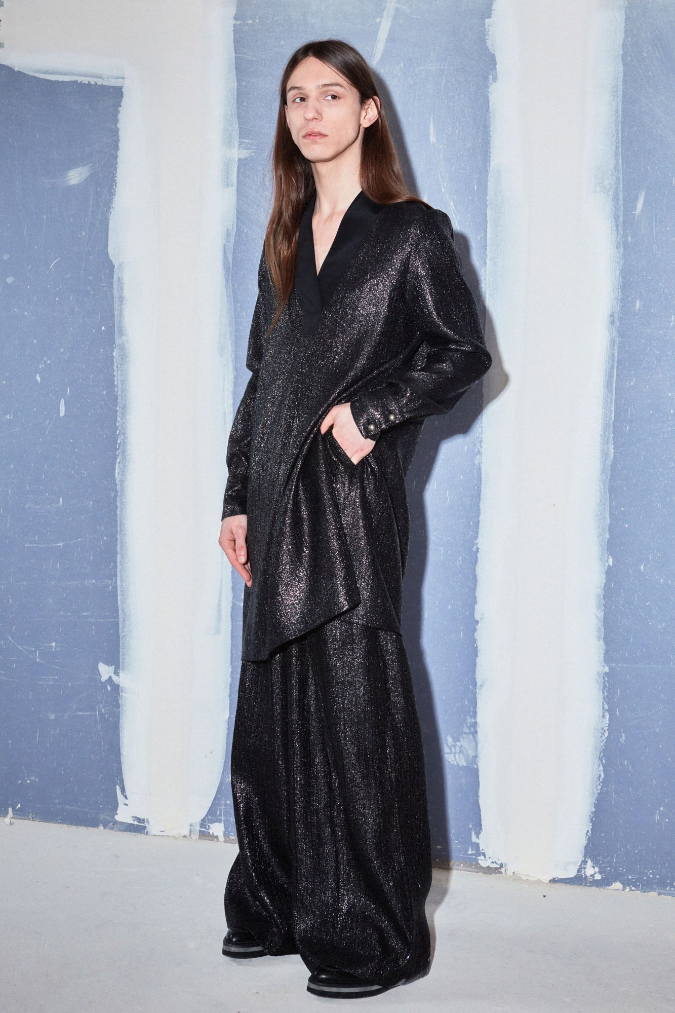 model wearing an oversized jacket and trouser combo in shimmery black fabric, by Benjamin Benmoyal