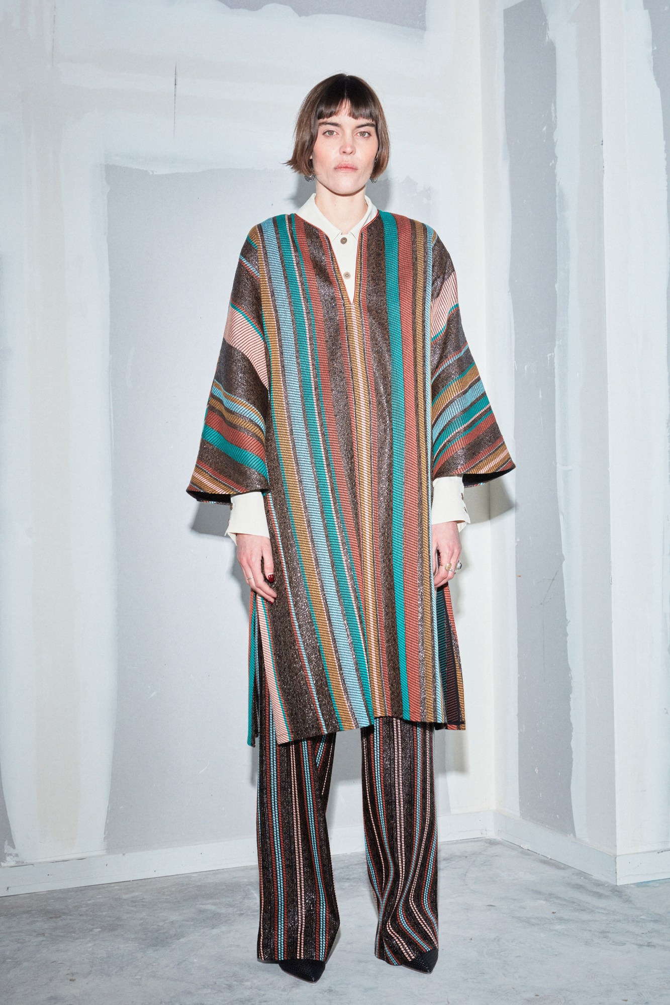 model wearing a matching tunic and trouser combo in blues and browns, by Benjamin Benmoyal