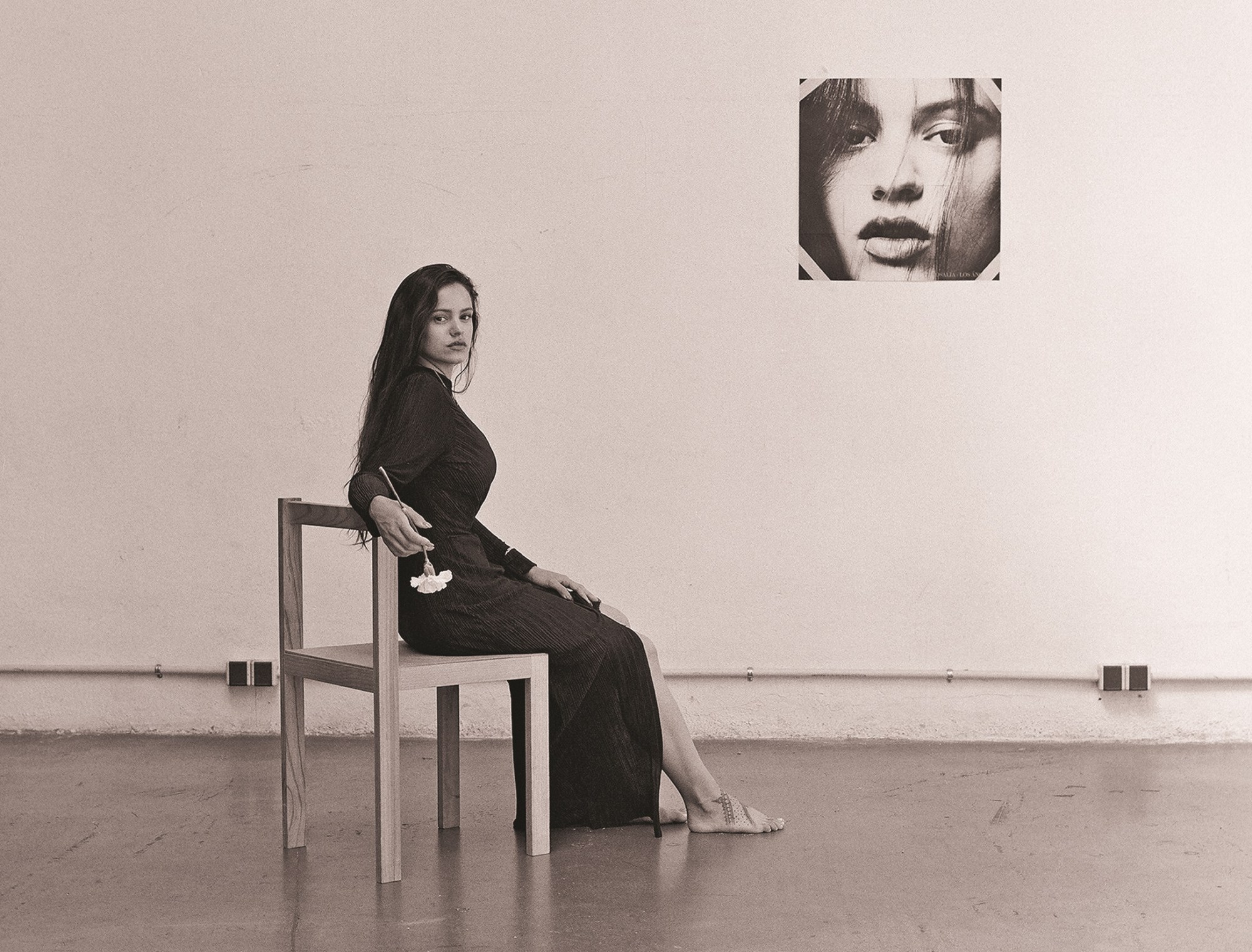 rosalia sitting in a chair and holding a flower photographed by carlota guerrero