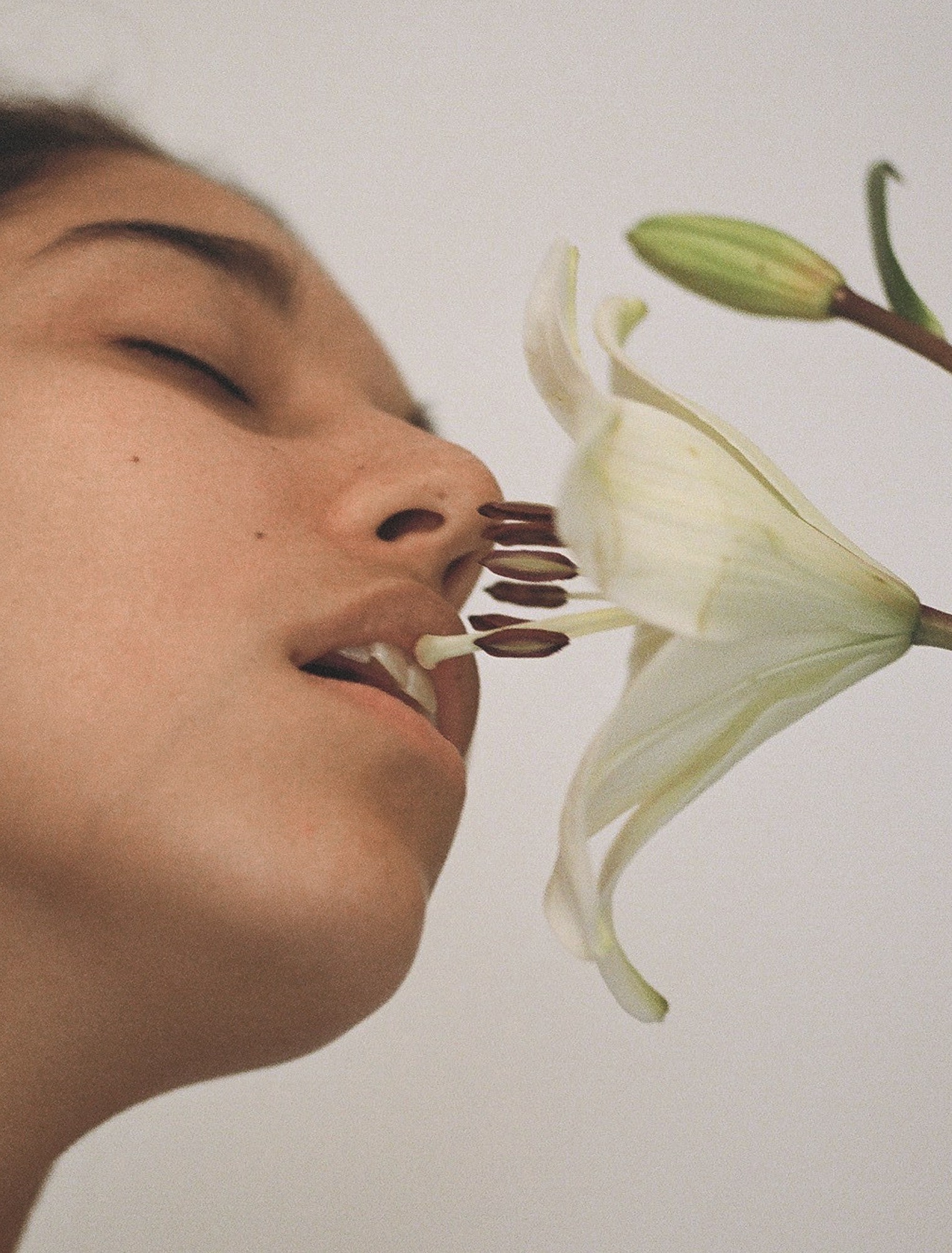 a woman with her mouth on a lily photographed by carlota guerrero