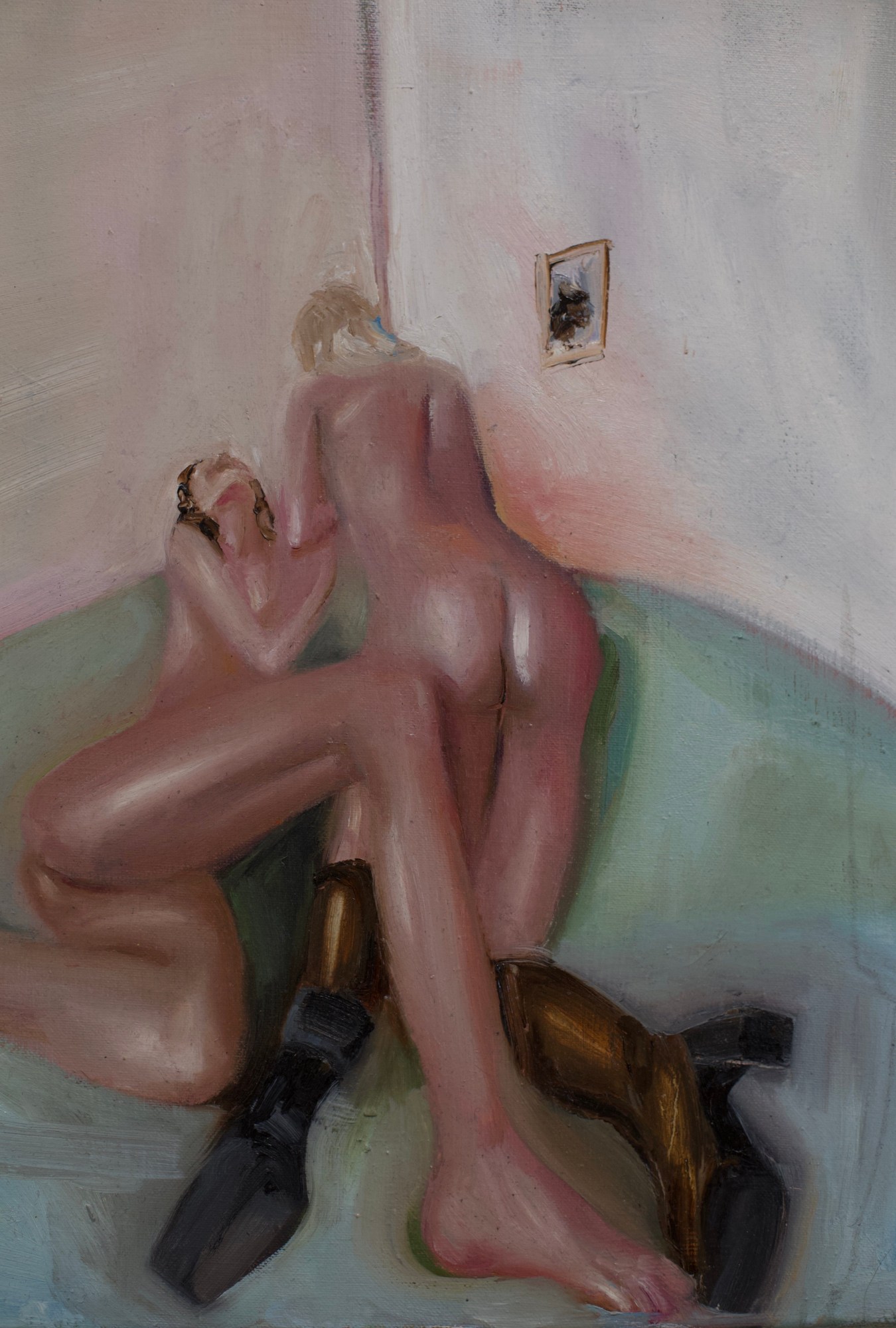 two nude woman rolling around on a bed, one wearing black boots