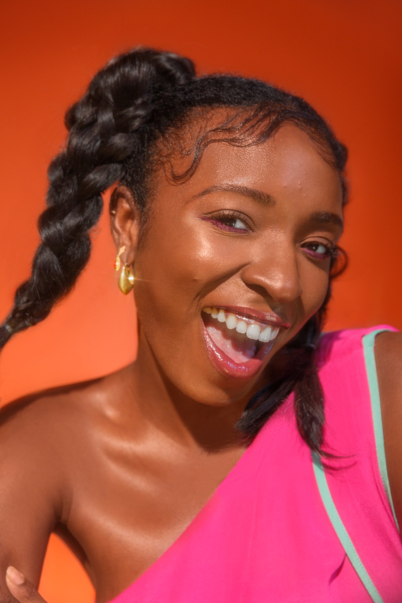 Woman smiling with teeth in pink one shoulder top