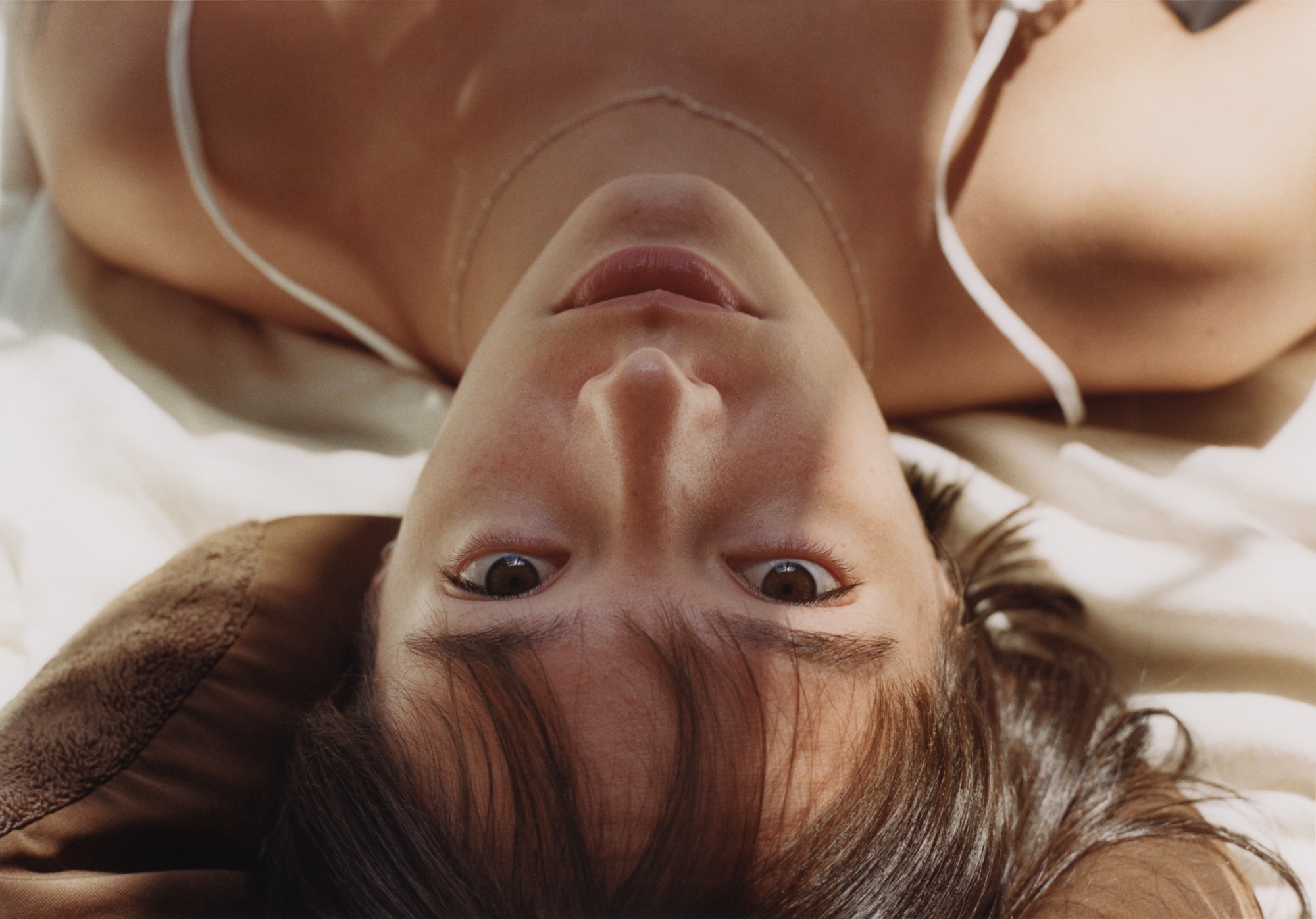 a woman lying down looks up at the camera above her