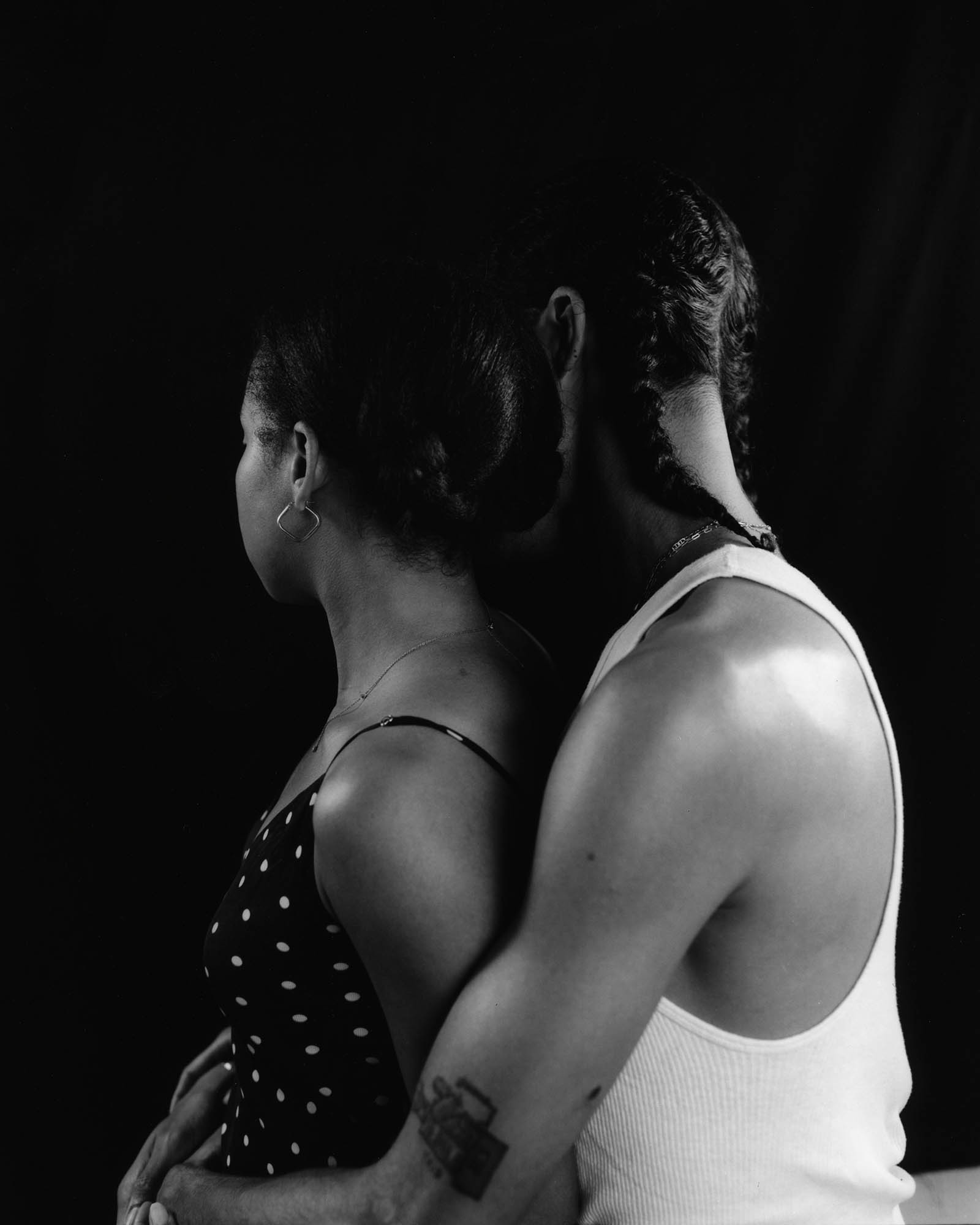 a man holds wraps his arms around a woman from behind