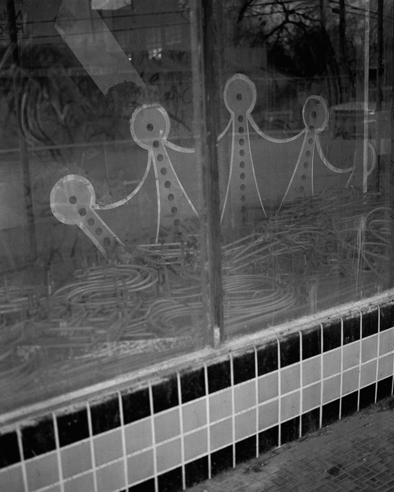 a desolate looking shop window with a crude drawing of people holding hands inside