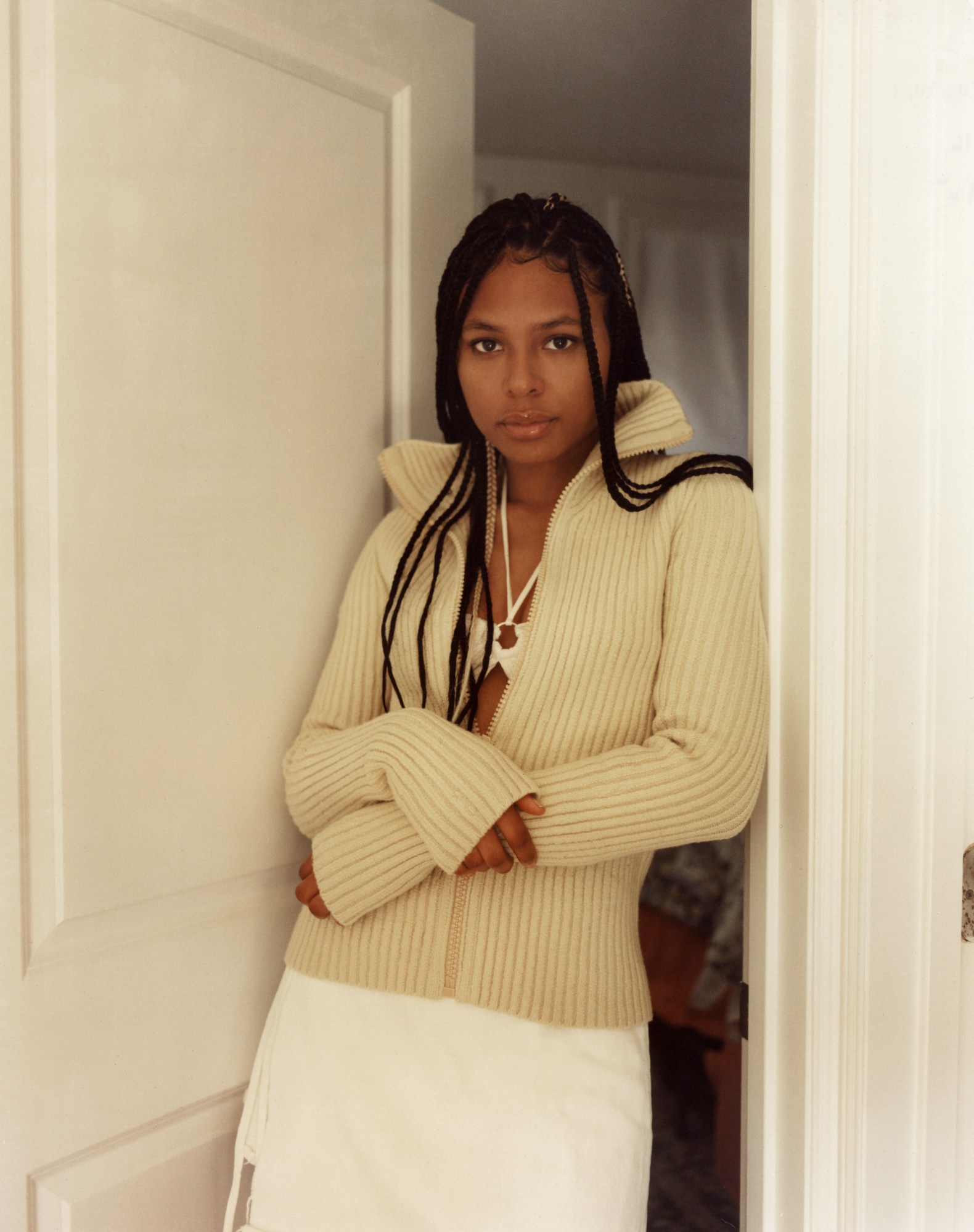 candace standing in the doorway of her room with her arms crossed