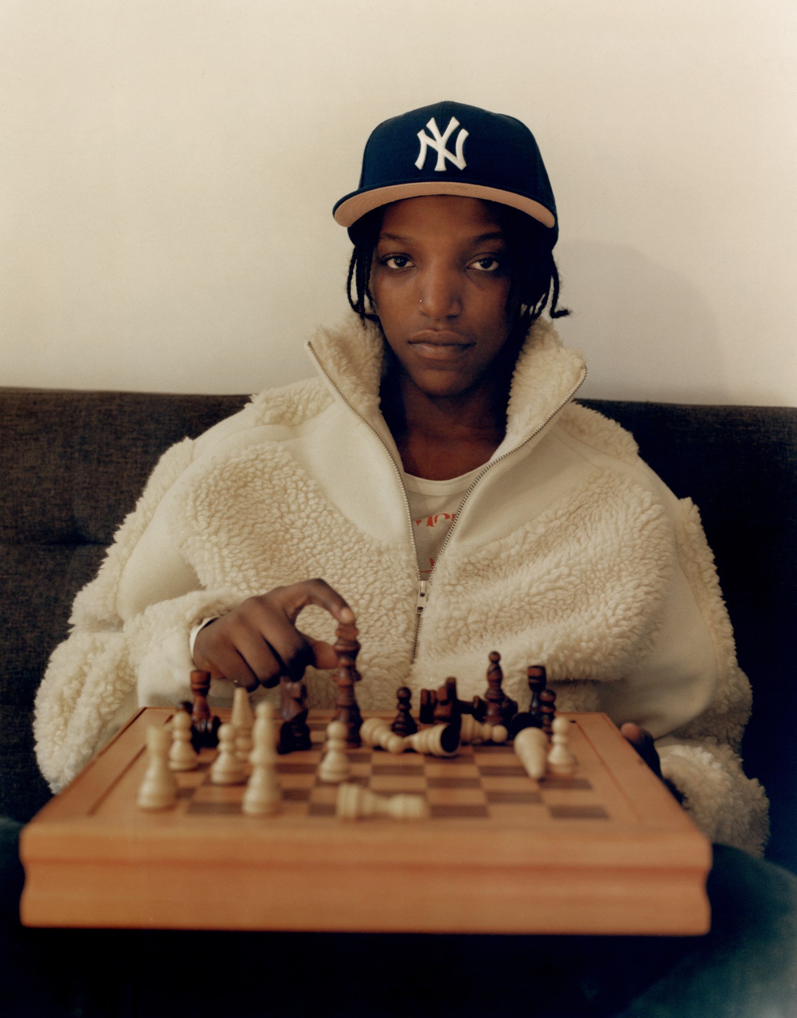 ace watkins playing chess and looking directly into the camera