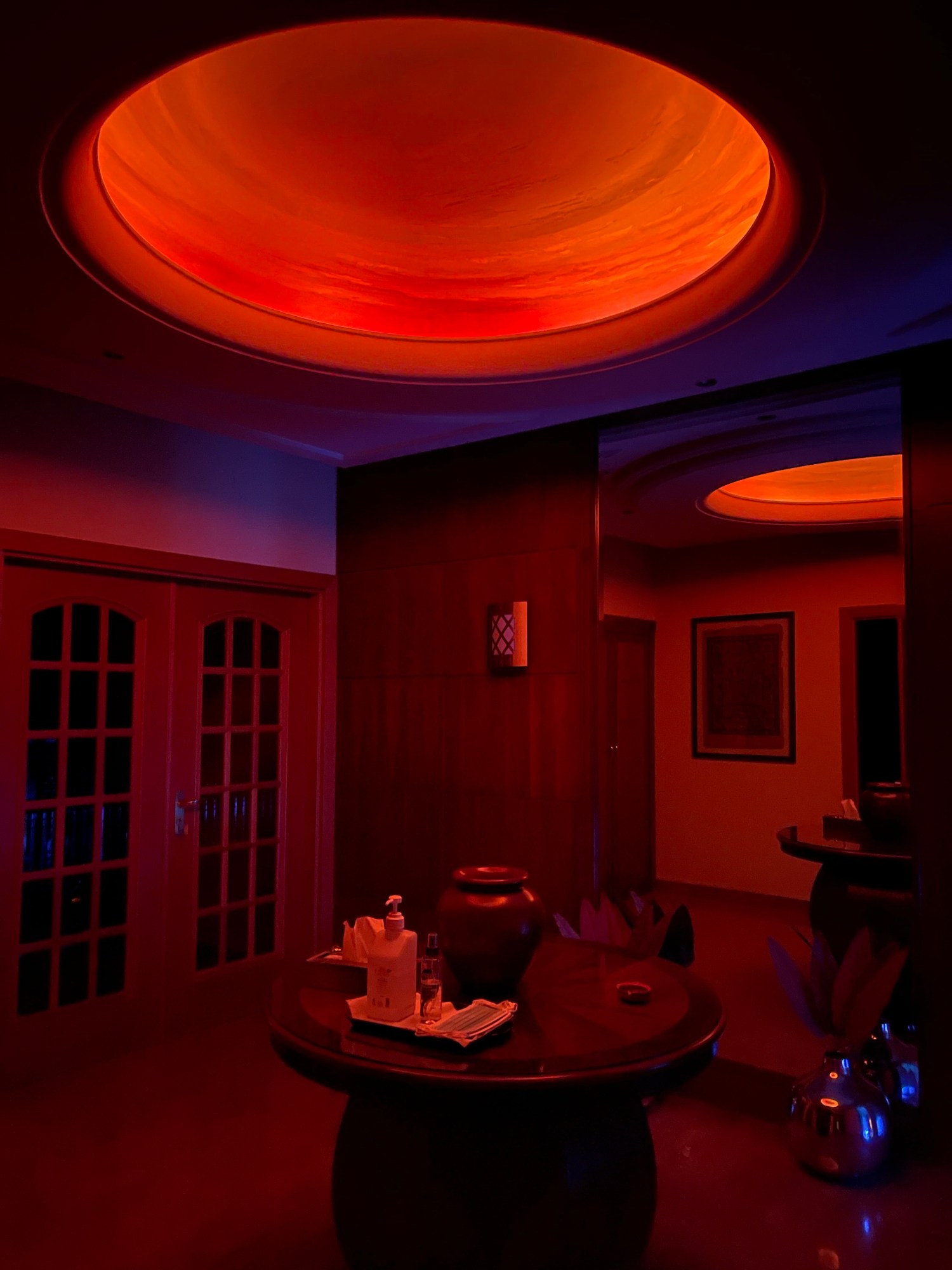 a red-lit entrance hall with a circle ceiling feature