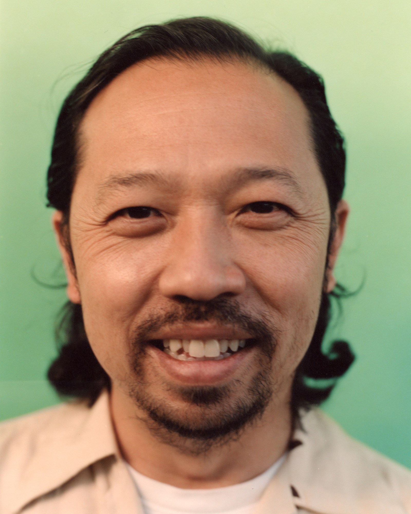 close up portrait of Humberto Leon against a green backdrop