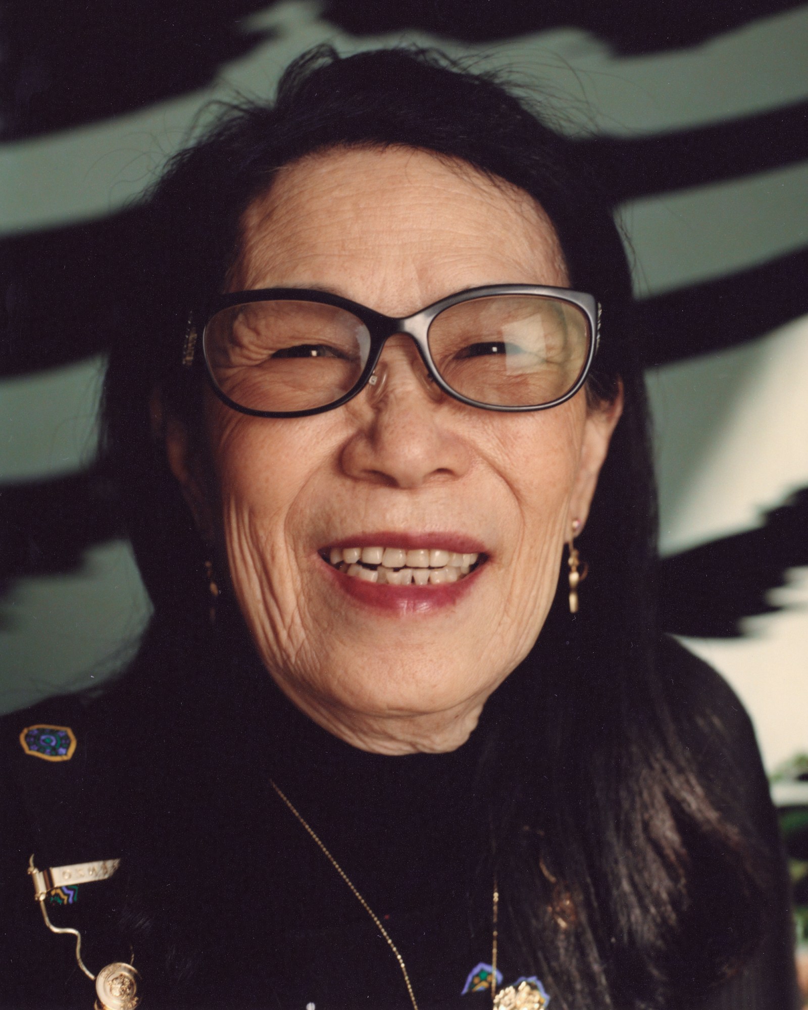 a close up portrait of Wendy Leon wearing glasses against a striped background