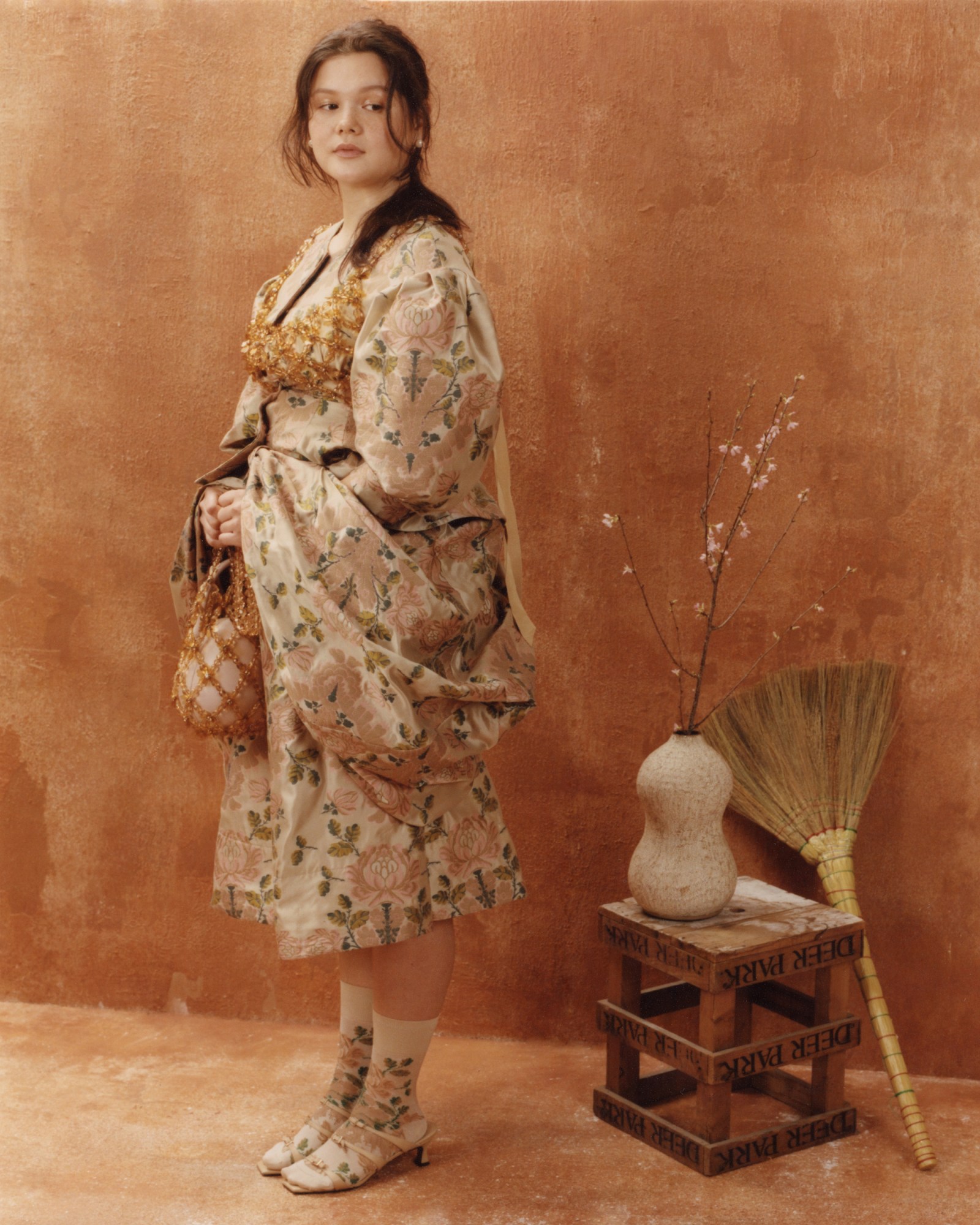 Anna Theroux Liang holding a beaded purse in her hand and looking over her shoulder