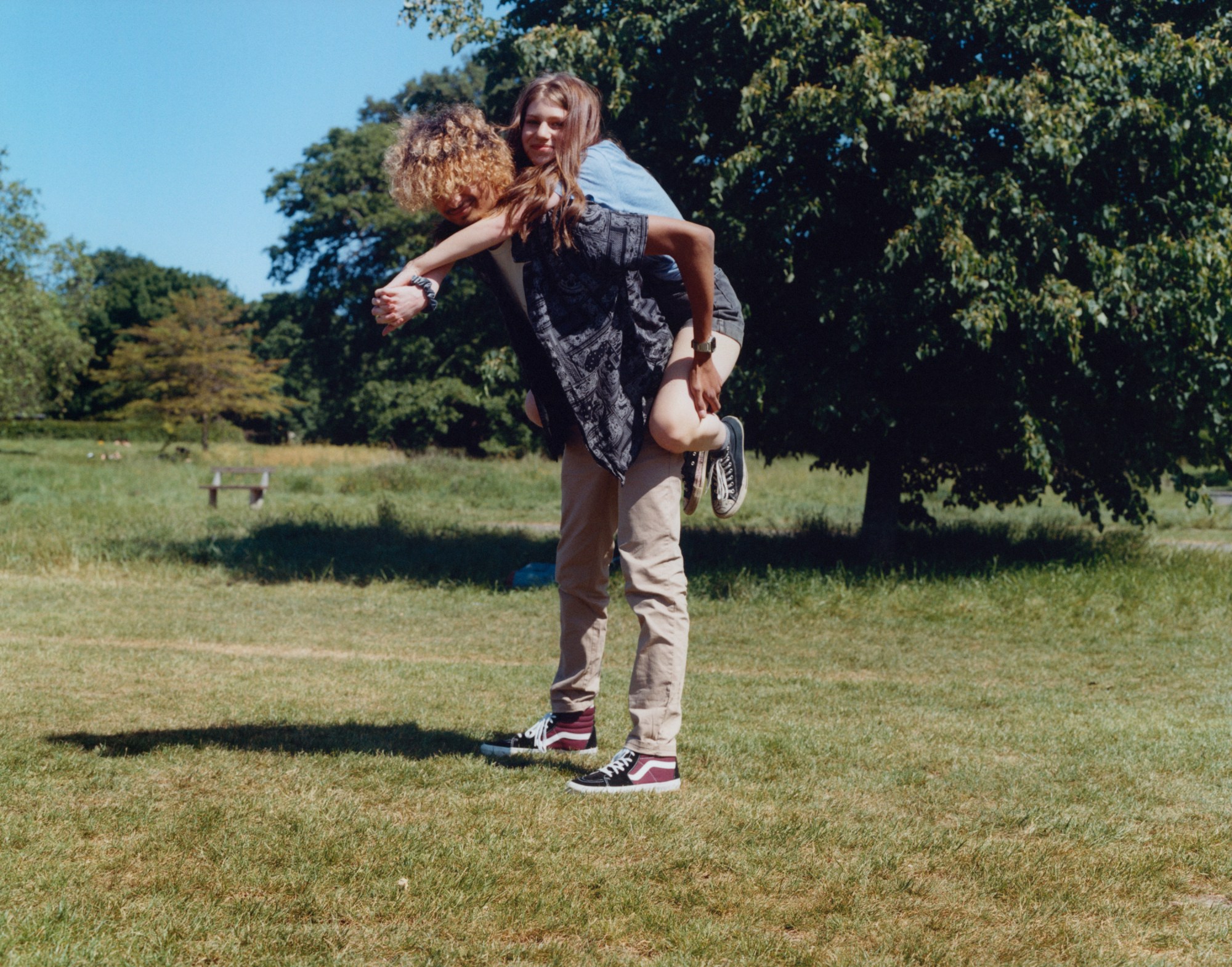 a girl gets a piggy back from a boy with dyed hair