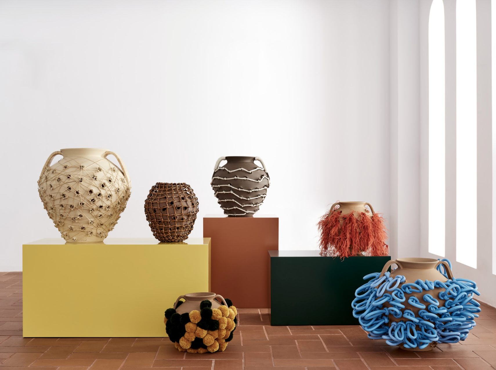 six abstract pots made from clay chestnut roasters, displayed on plinths