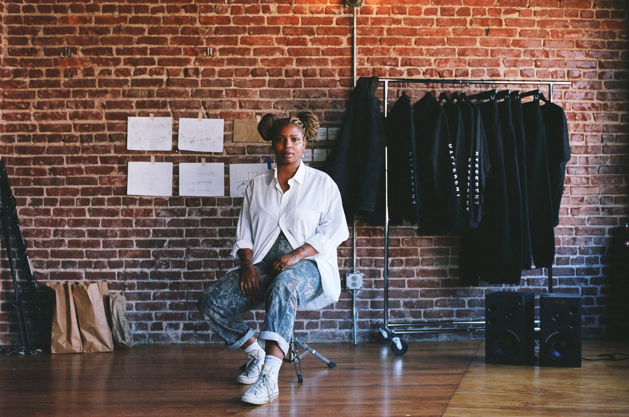 honey simone sitting in a chair in front of a brick wall