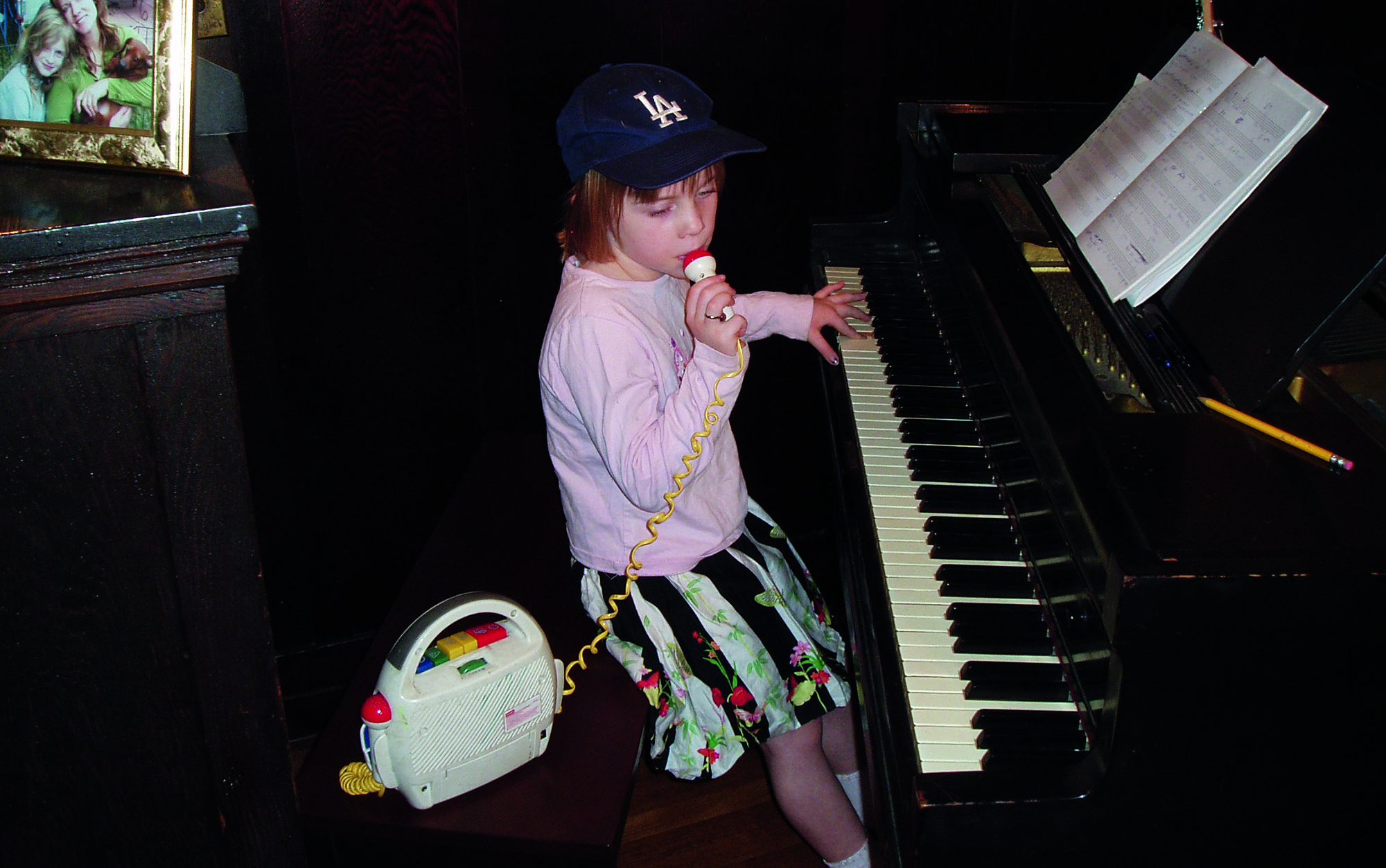 billie eilish as a baby by a piano playing music