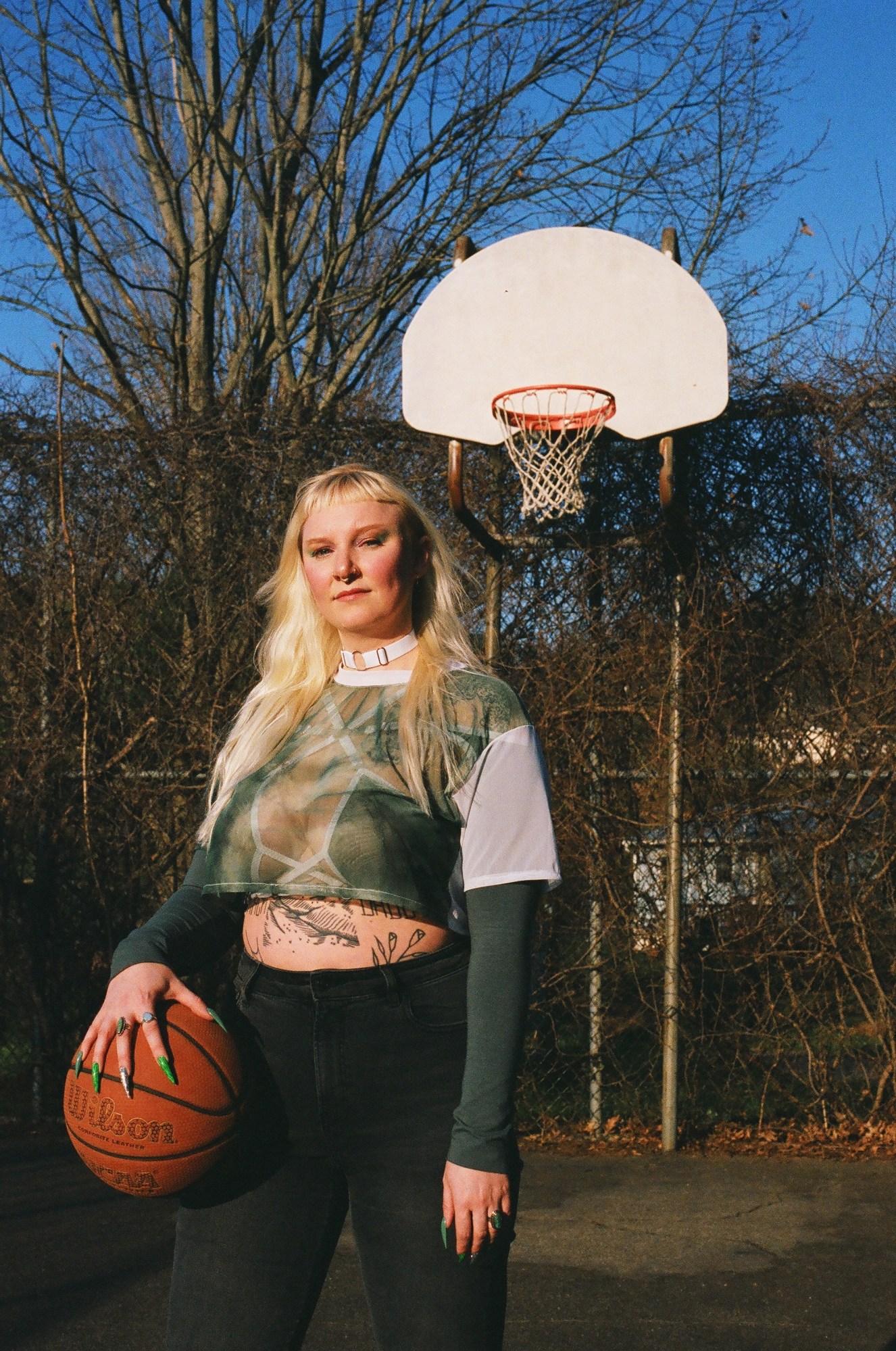 ae silver on a basketball court holding a ball in her hand