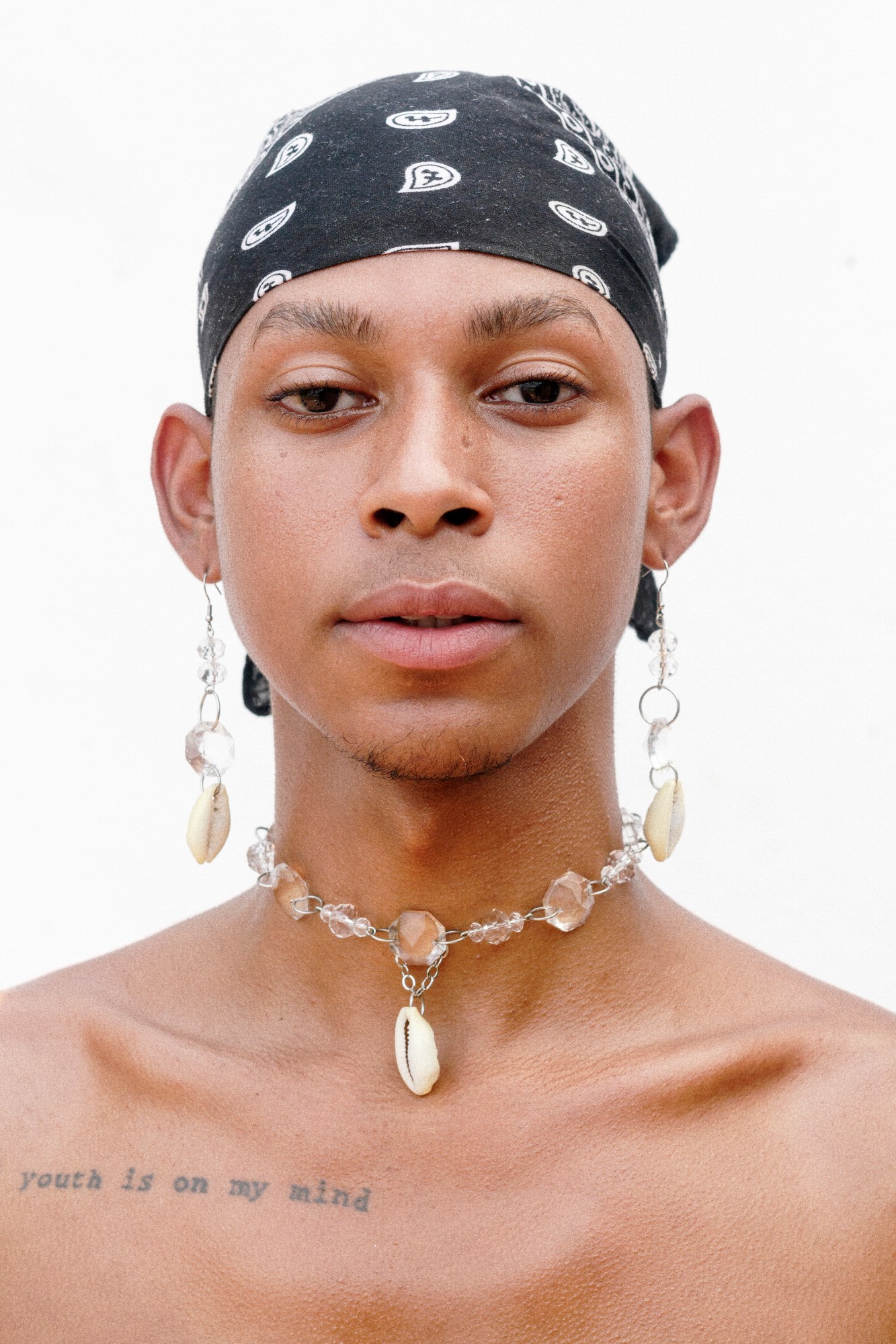 a brazilian man with a bandana on his head and shell jewelry