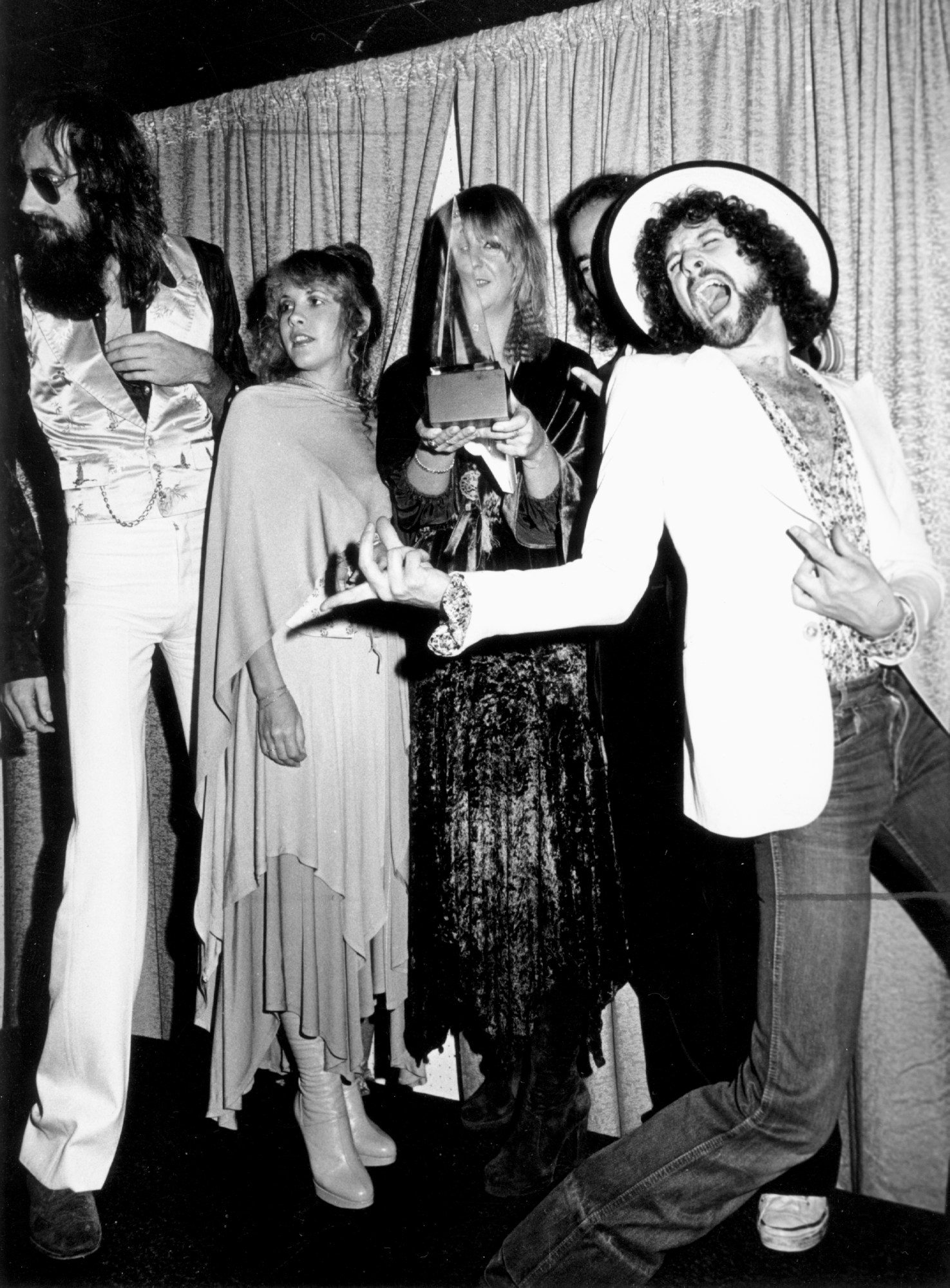 stevie nicks posing with fleetwood mac and their album of the year AMAs award