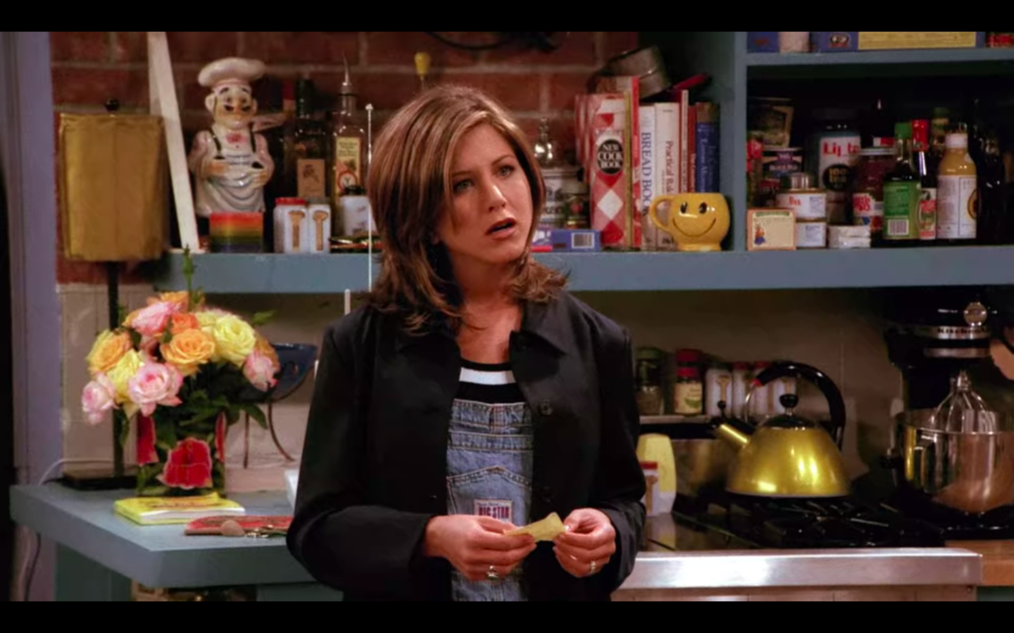 Jennifer Aniston as Rachel Green in Friends wearing denim shortalls and a black blazer