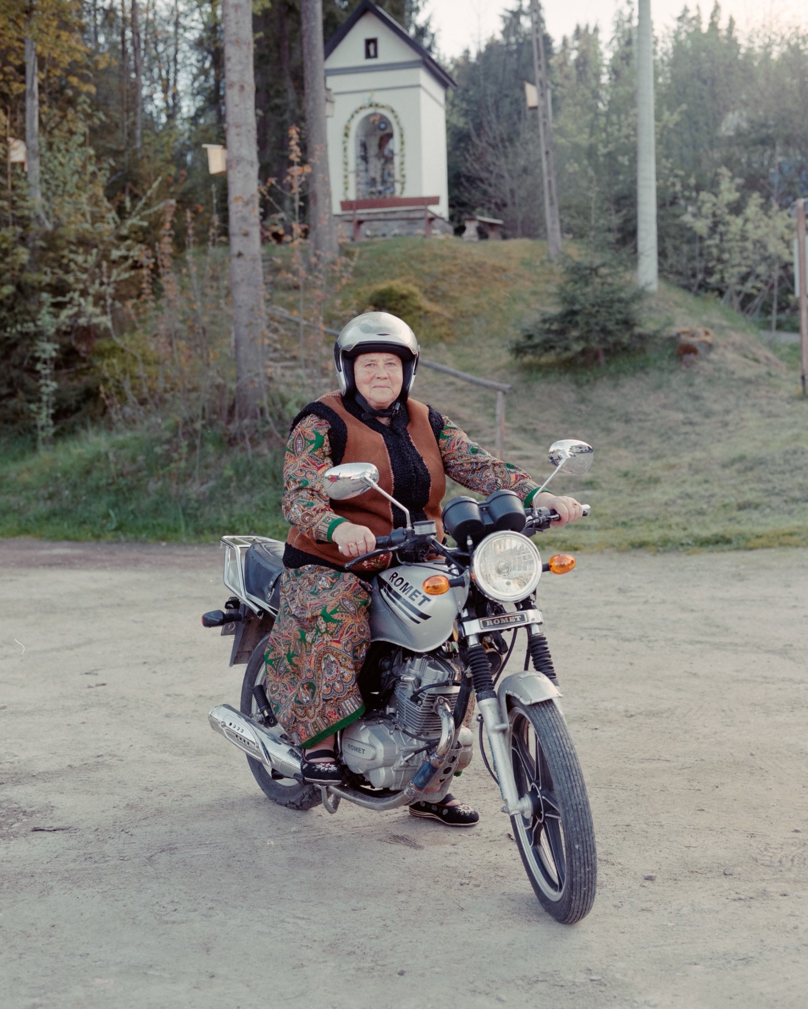 A polish woman in a traditional dress on a motorbike.