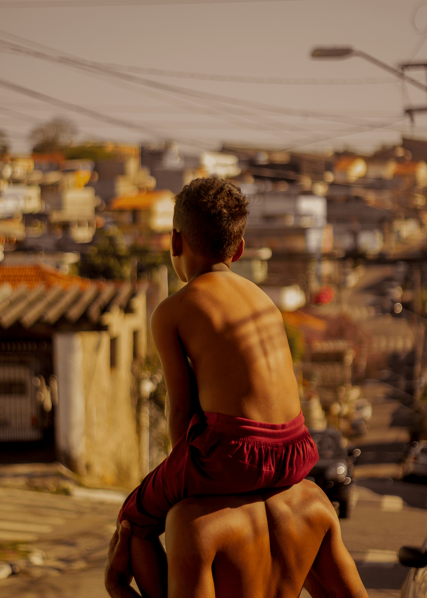 a child sitting on a man's shoulders as both look out over the city of Sao Paulo.