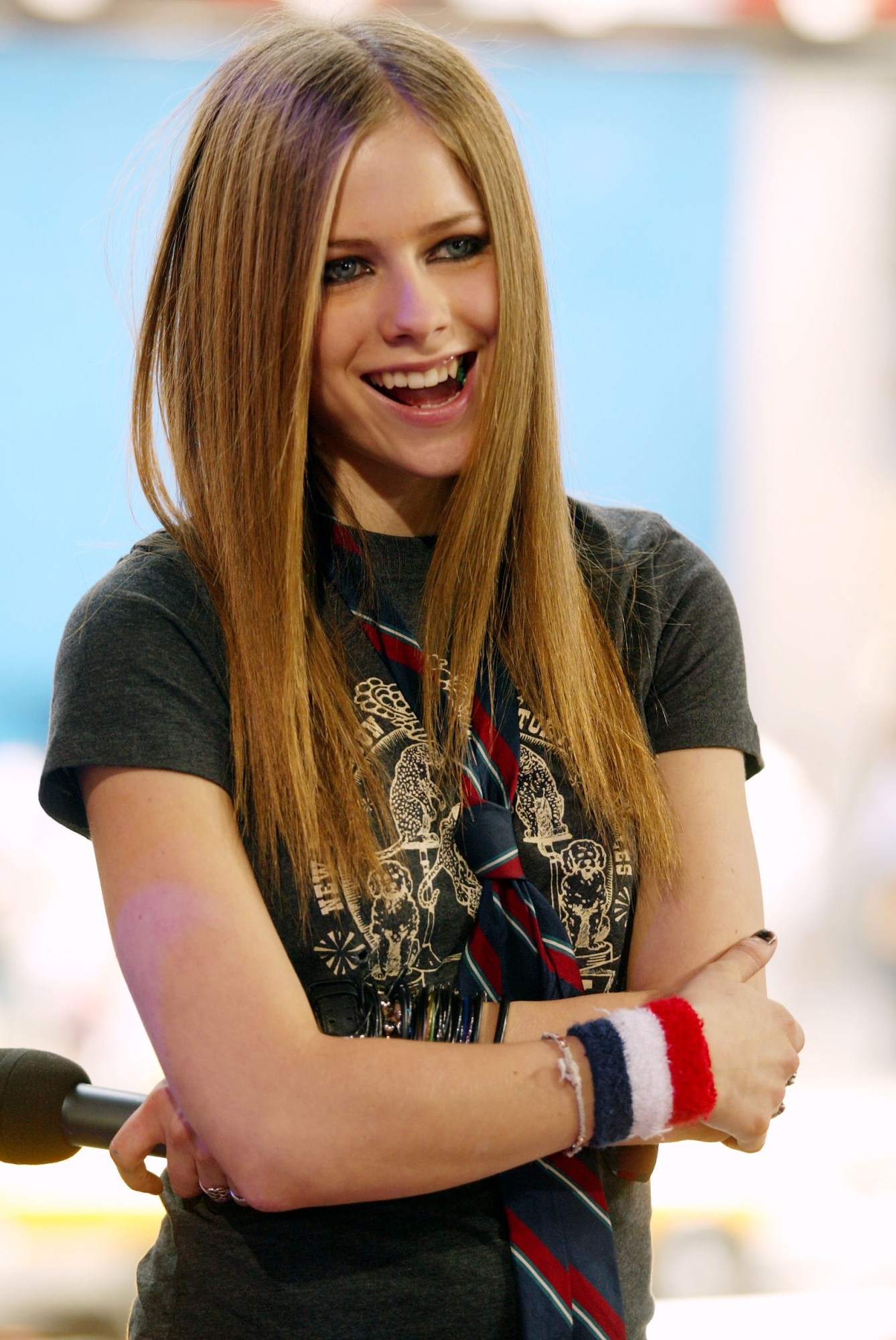 avril lavigne standing with her arms crossed and wearing a tie.