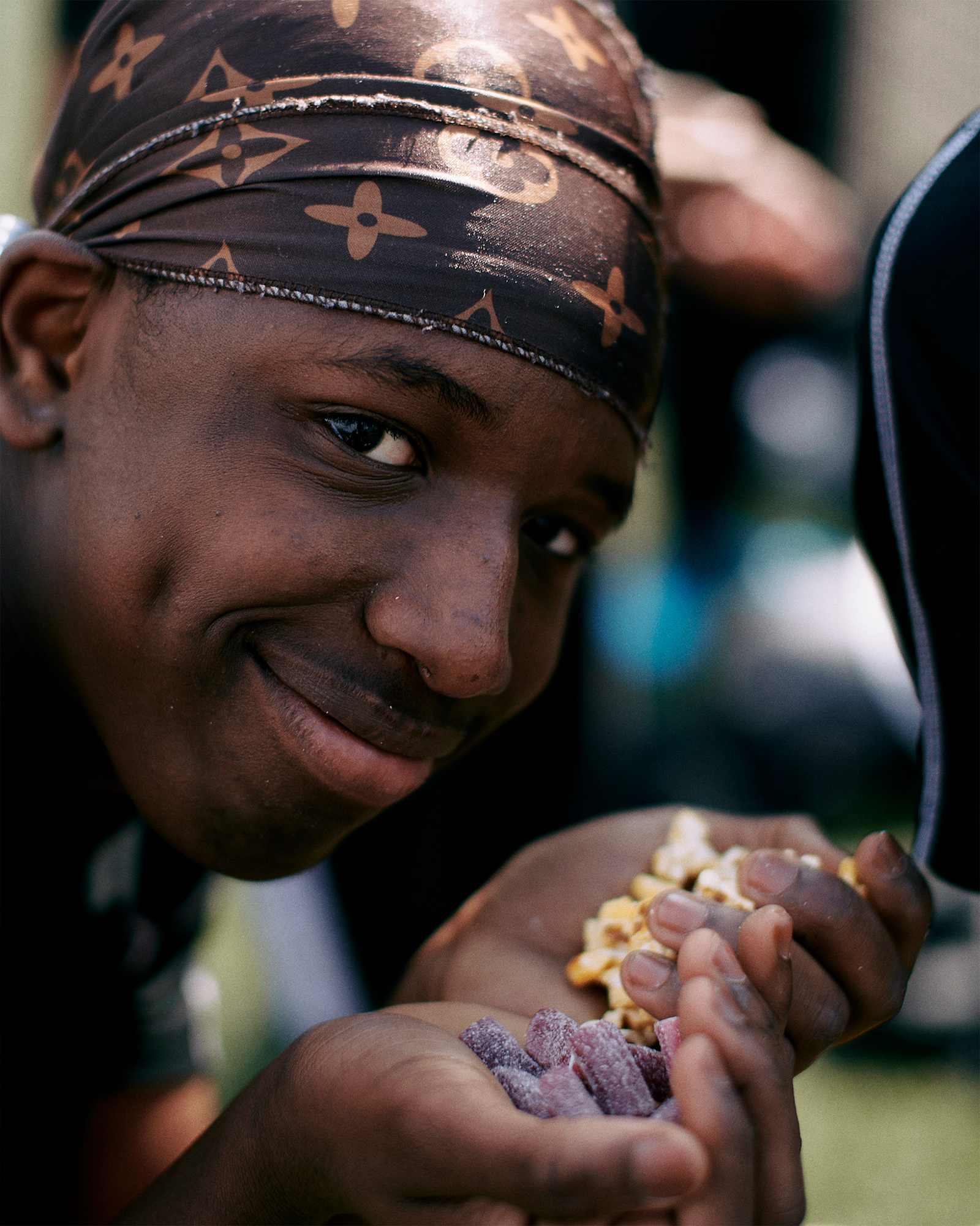 Close up of a boy smiling while holding handfuls of food