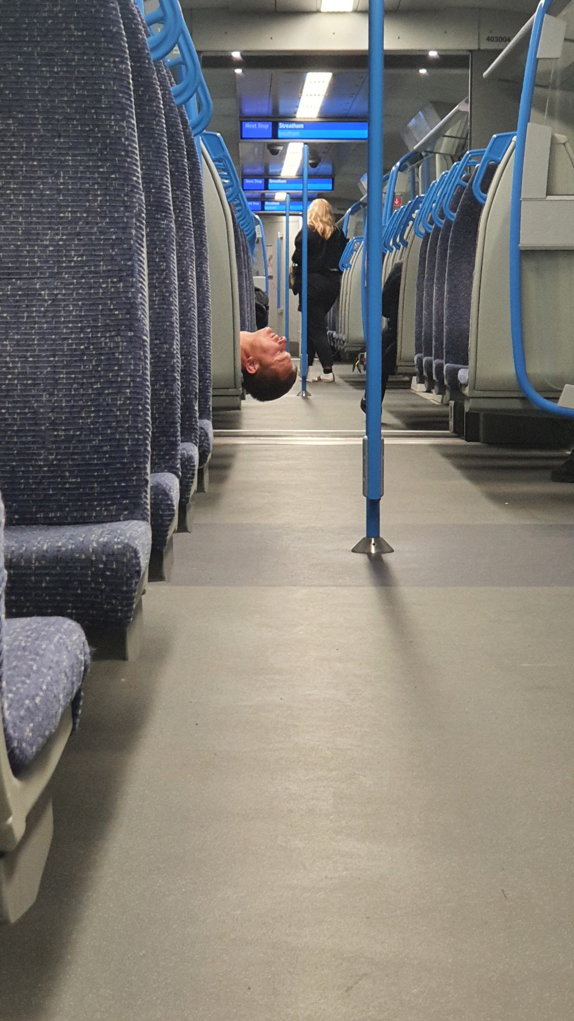 A man's head sticking out in the aisle of a thameslink train in London