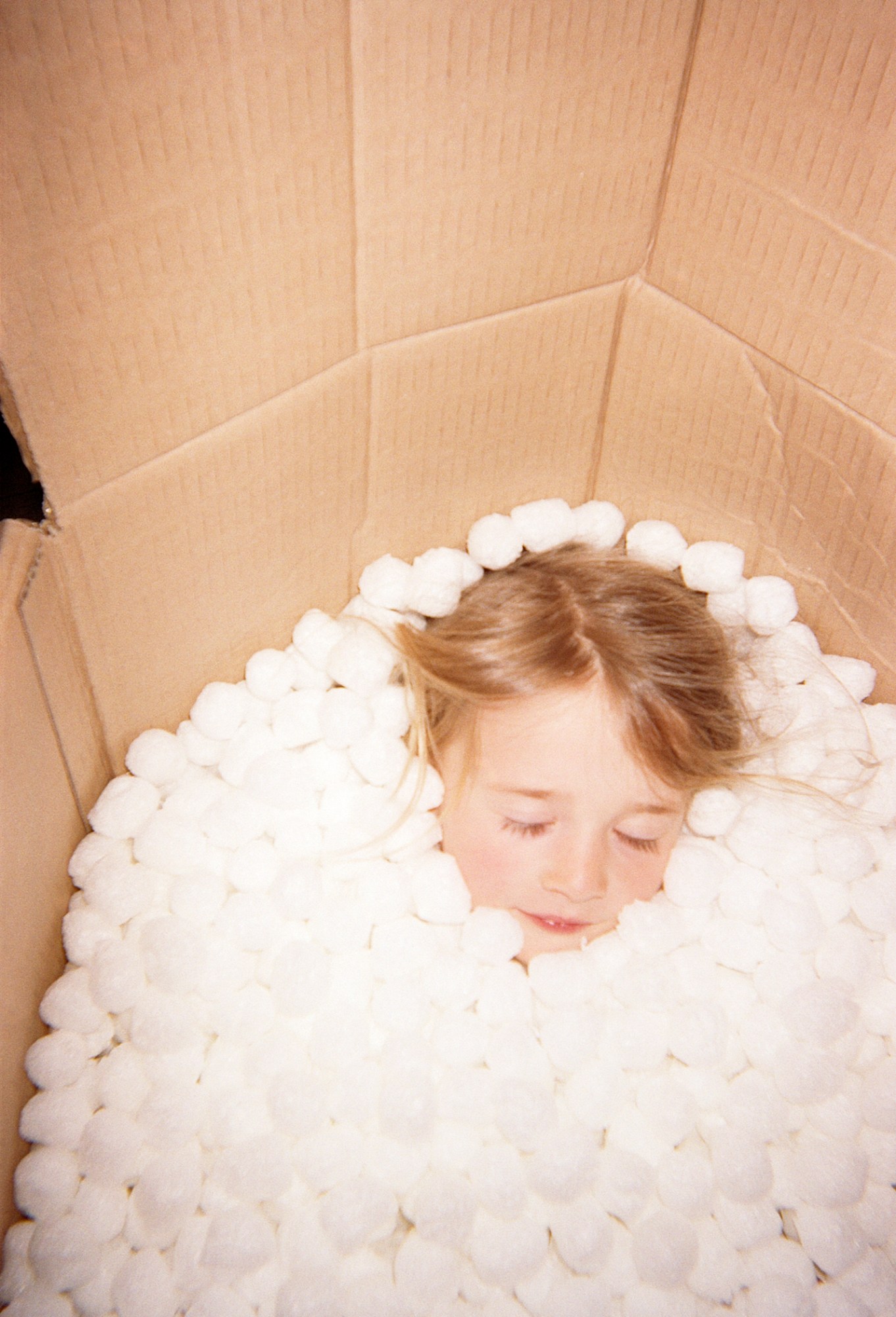 a young girl in a box of styrofoam