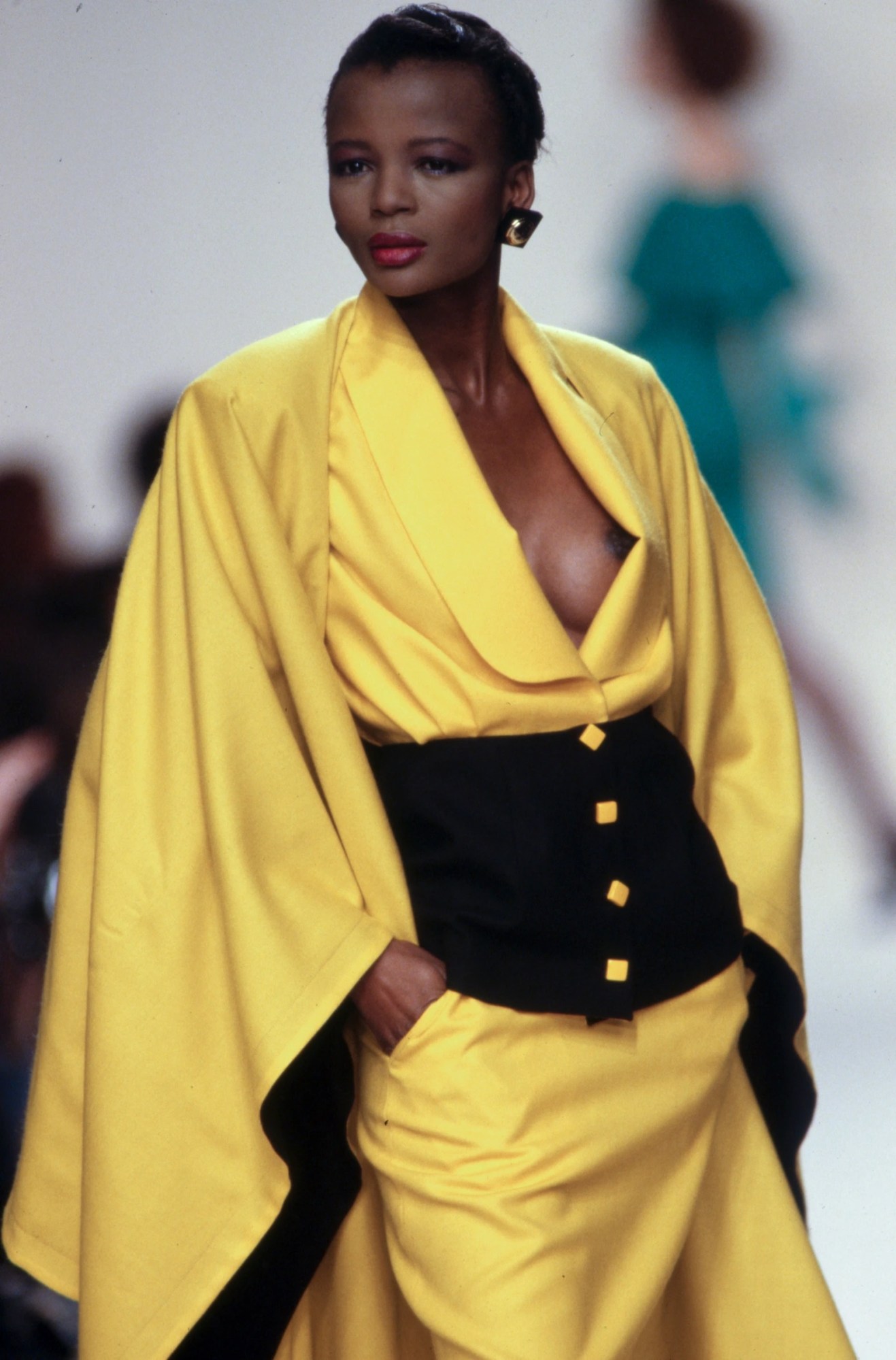 A model walking the runway at in flowing yellow gown at Patrick Kelly's AW89 show