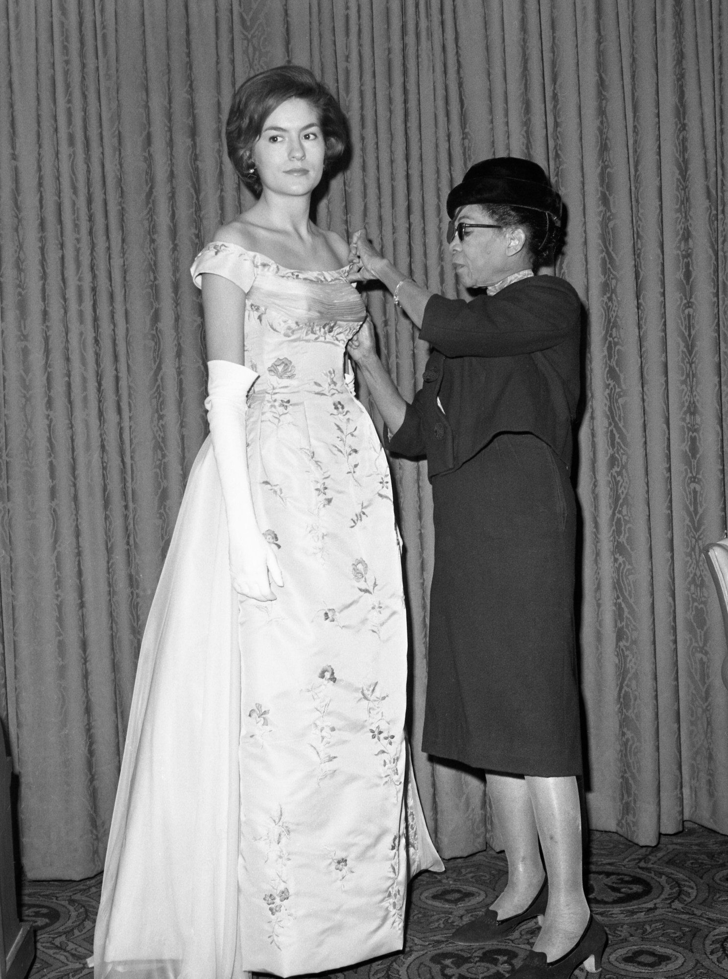 Fashion designer Ann Lowe adjusting the bodice of a client's dress