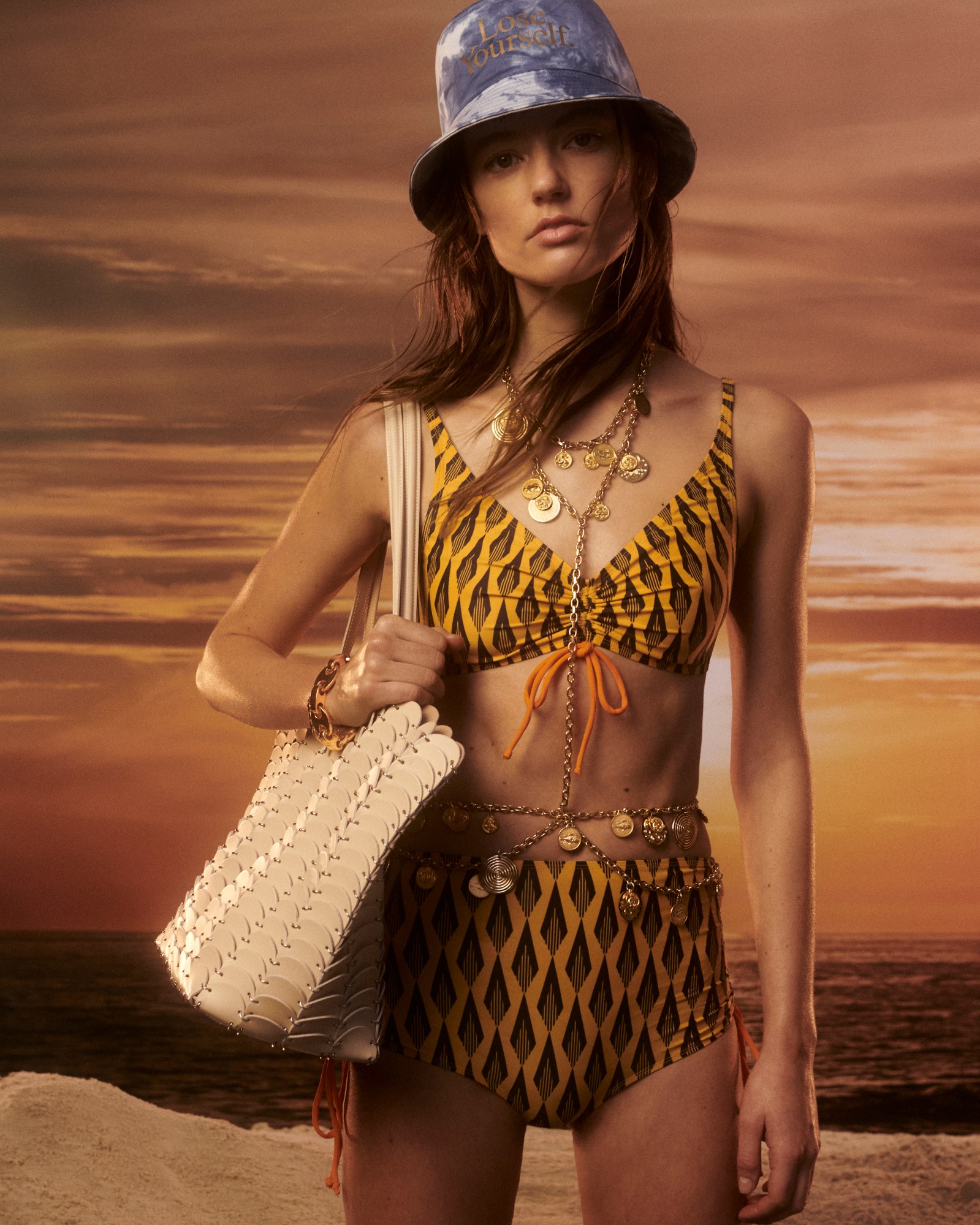 A model wearing a bucket hat and swimsuit from Paco Rabanne's Ciao Paco collection