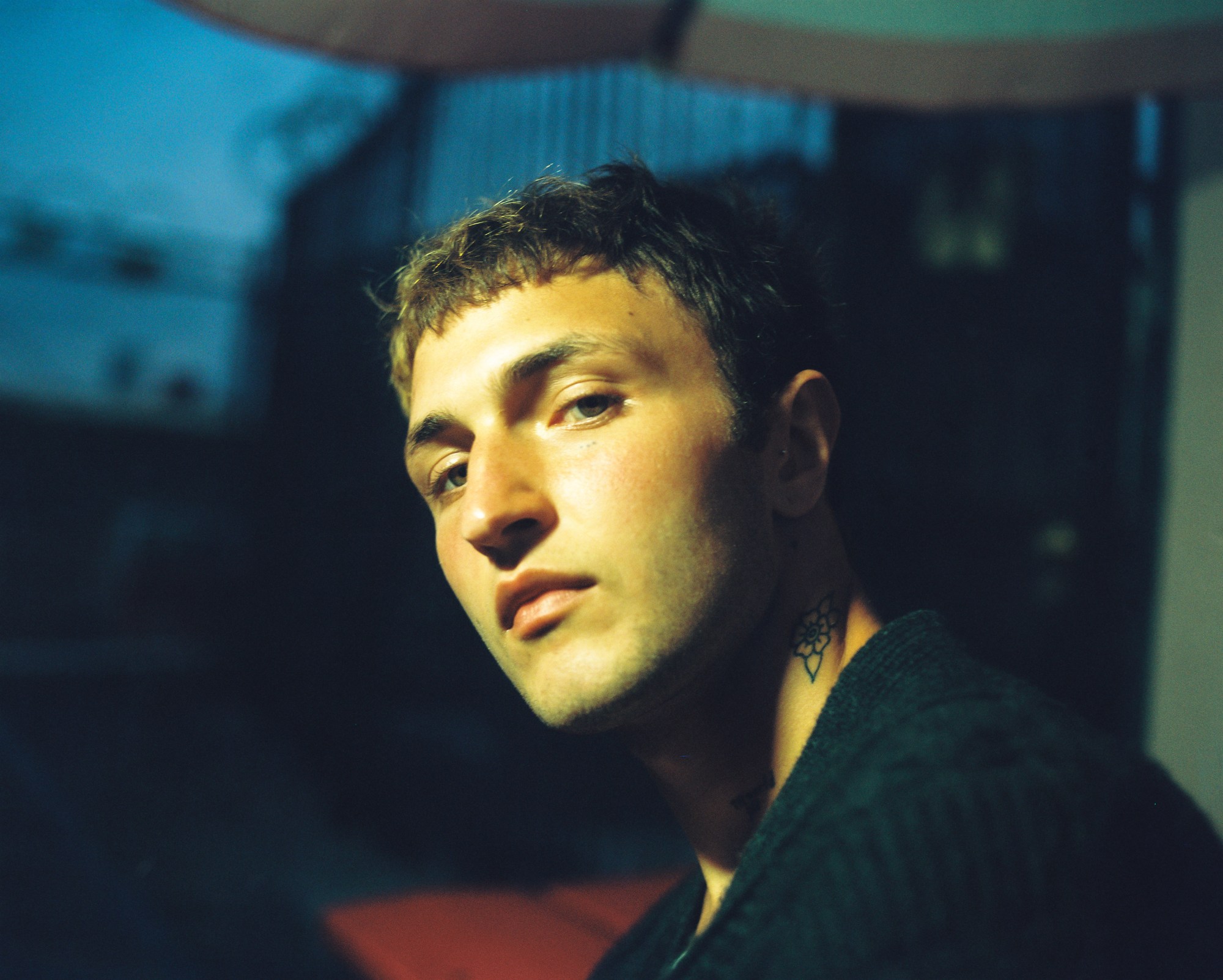 Anwar Hadid looking over his shoulder with his neck tattoo visible