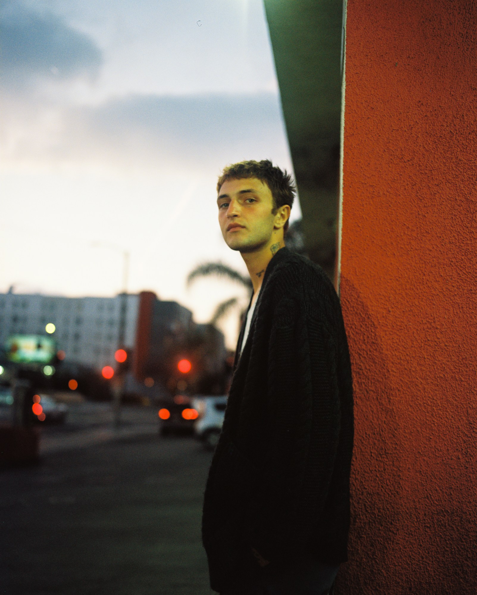 anwar hadid stood against a brick wall