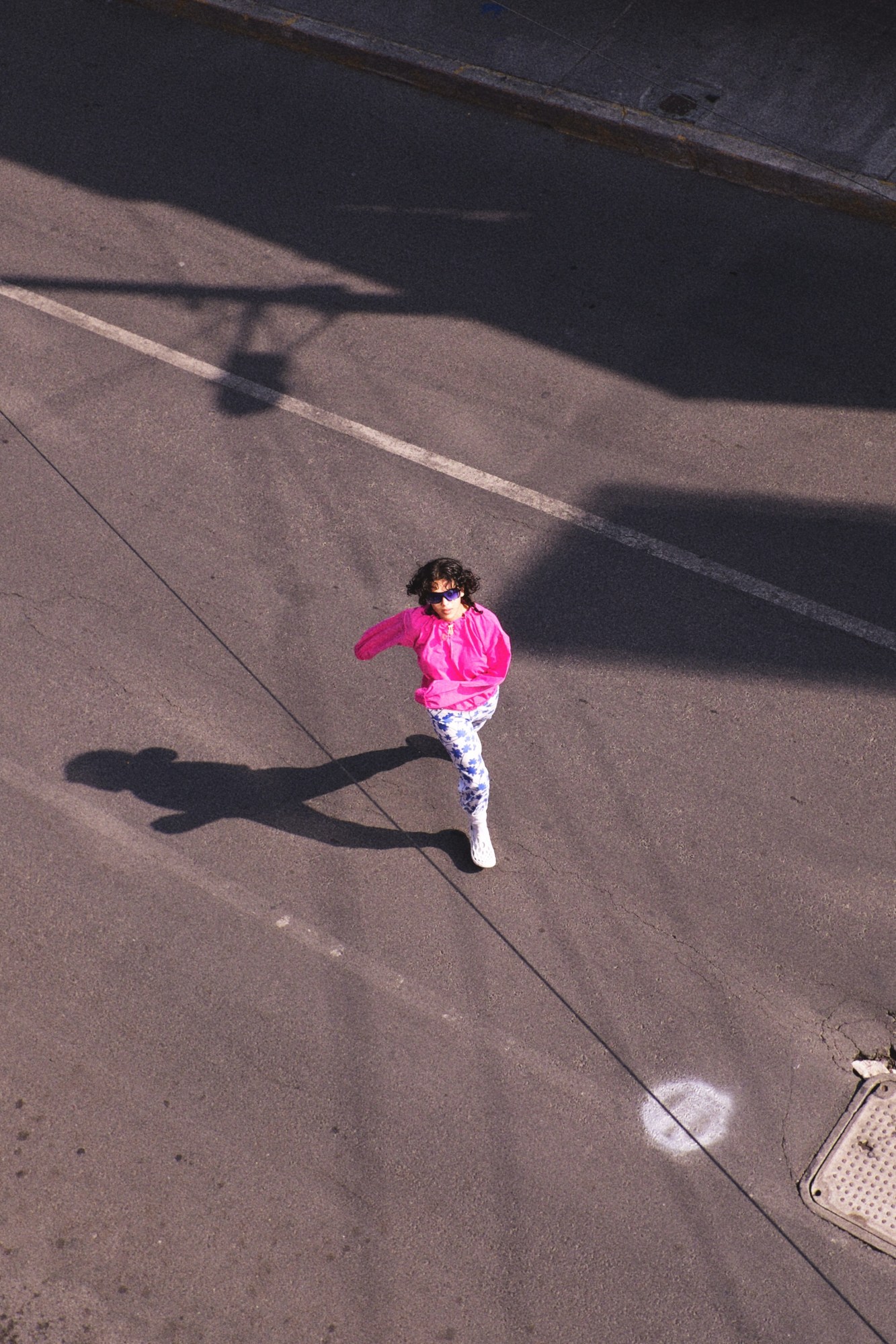 a model wearing bright colourful clothes by Katsu Clothing, running through the streets of Centro, Mexico City