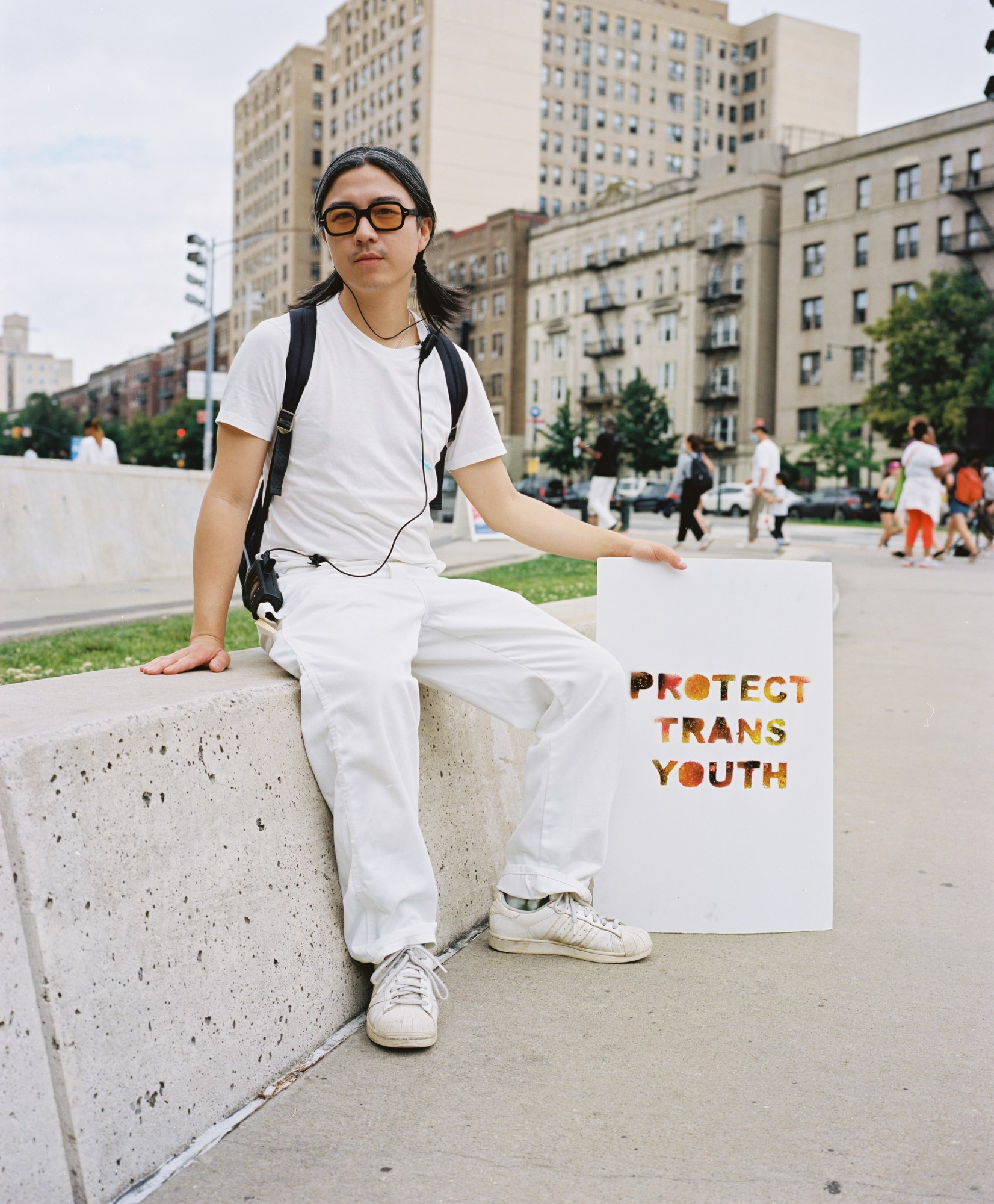 A person holding a sign that reads 'protect trans youth.'