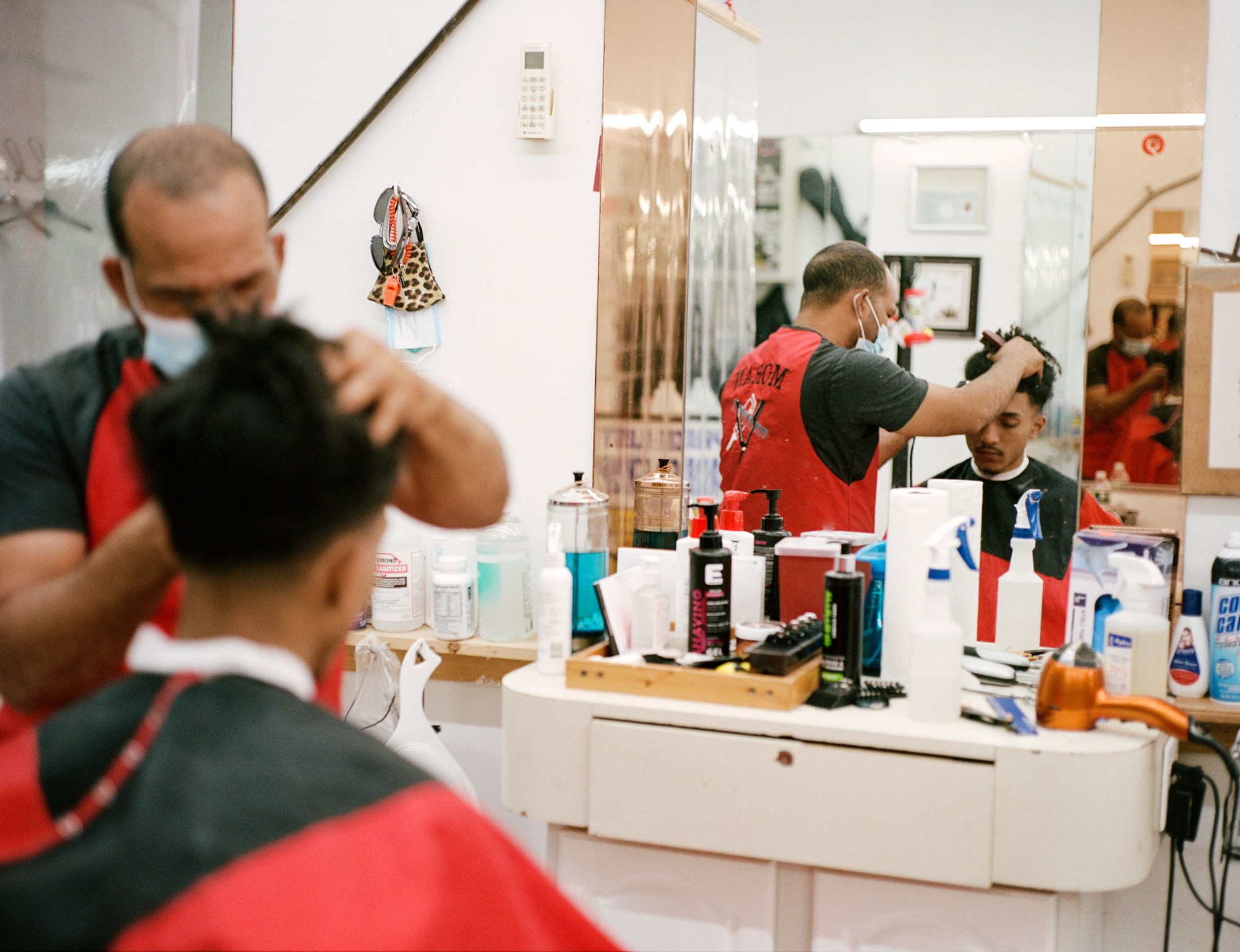 a man getting his hair cut at the barbershop by kadar small