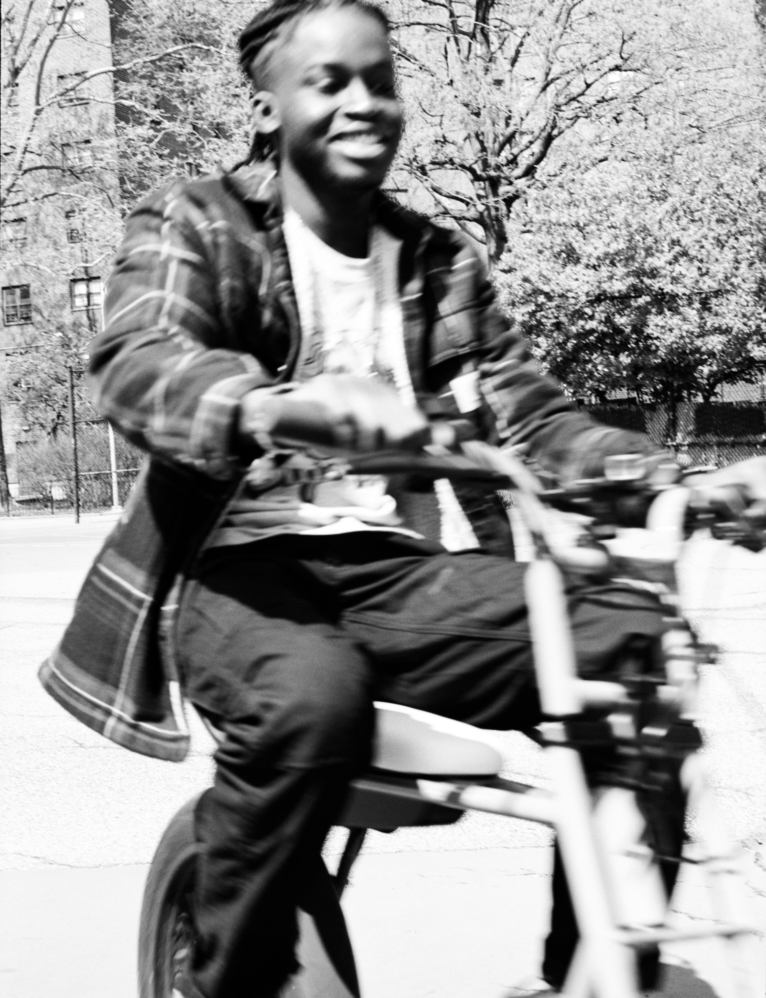 a boy laughing and riding a bike by kadar small