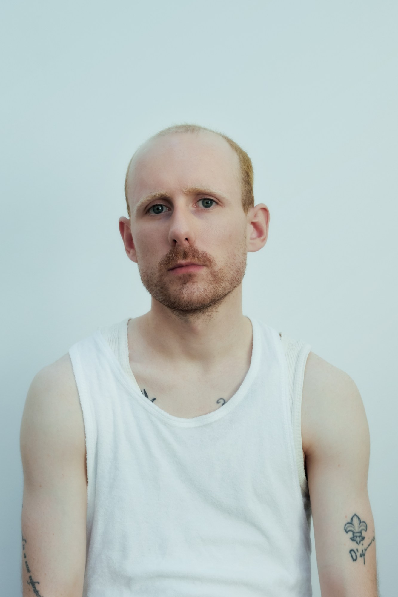 portrait of the artist wearing a white vest