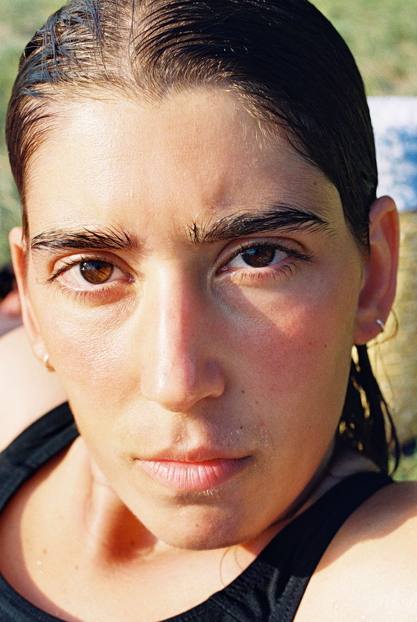 a woman with wet hair looks into the camera