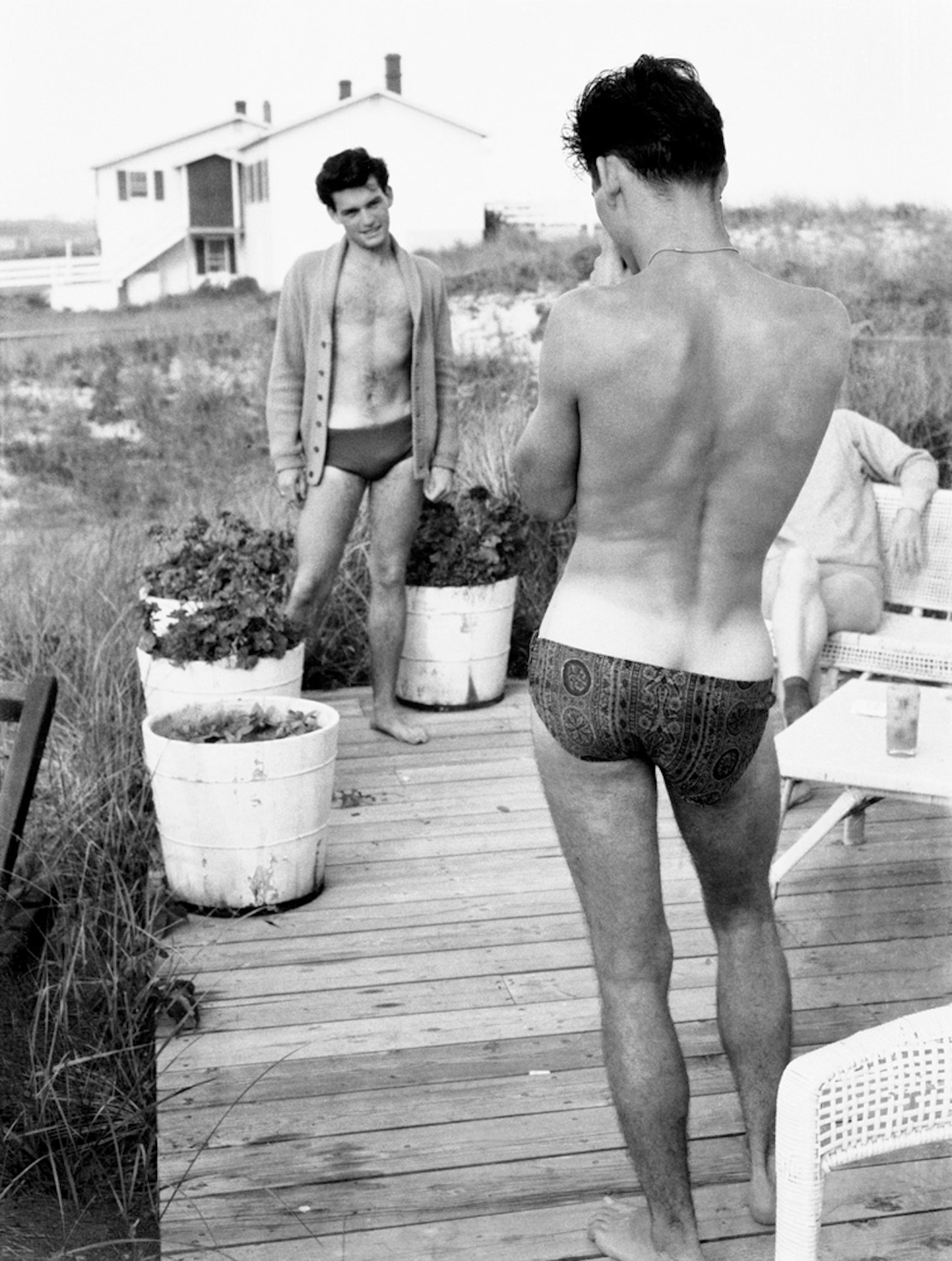 a shirtless young man posing for a picture in a speedo