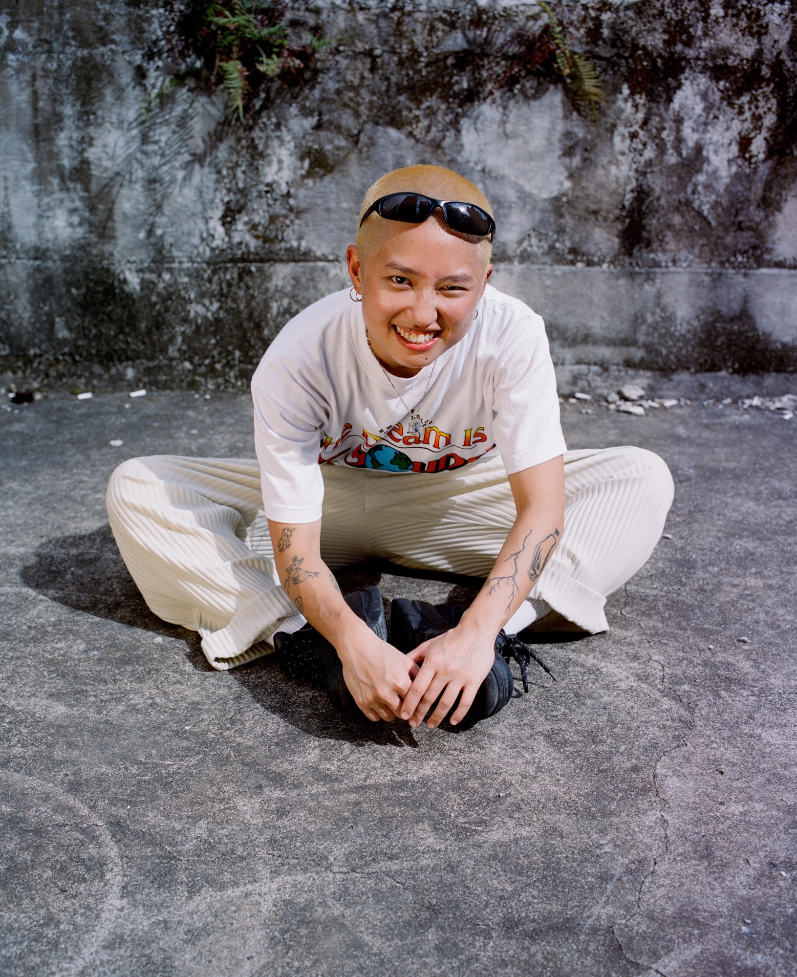 a portrait of winkie sitting cross legged on the concrete