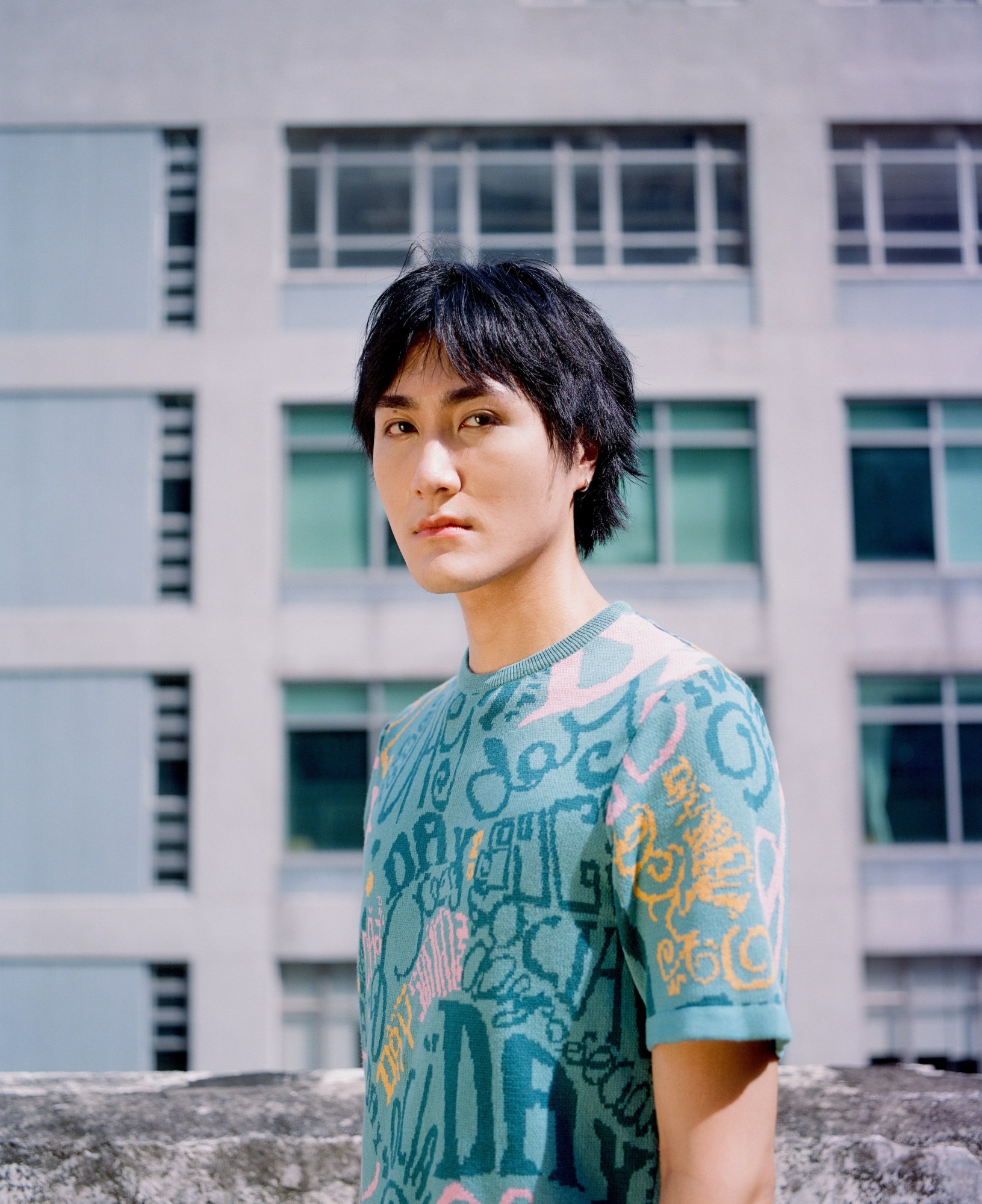 portrait of CK standing in front of a hong kong apartment building