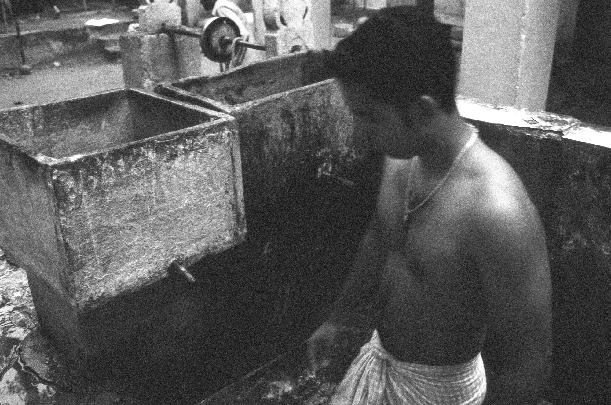 a man with wearing a necklace next to a tap of water