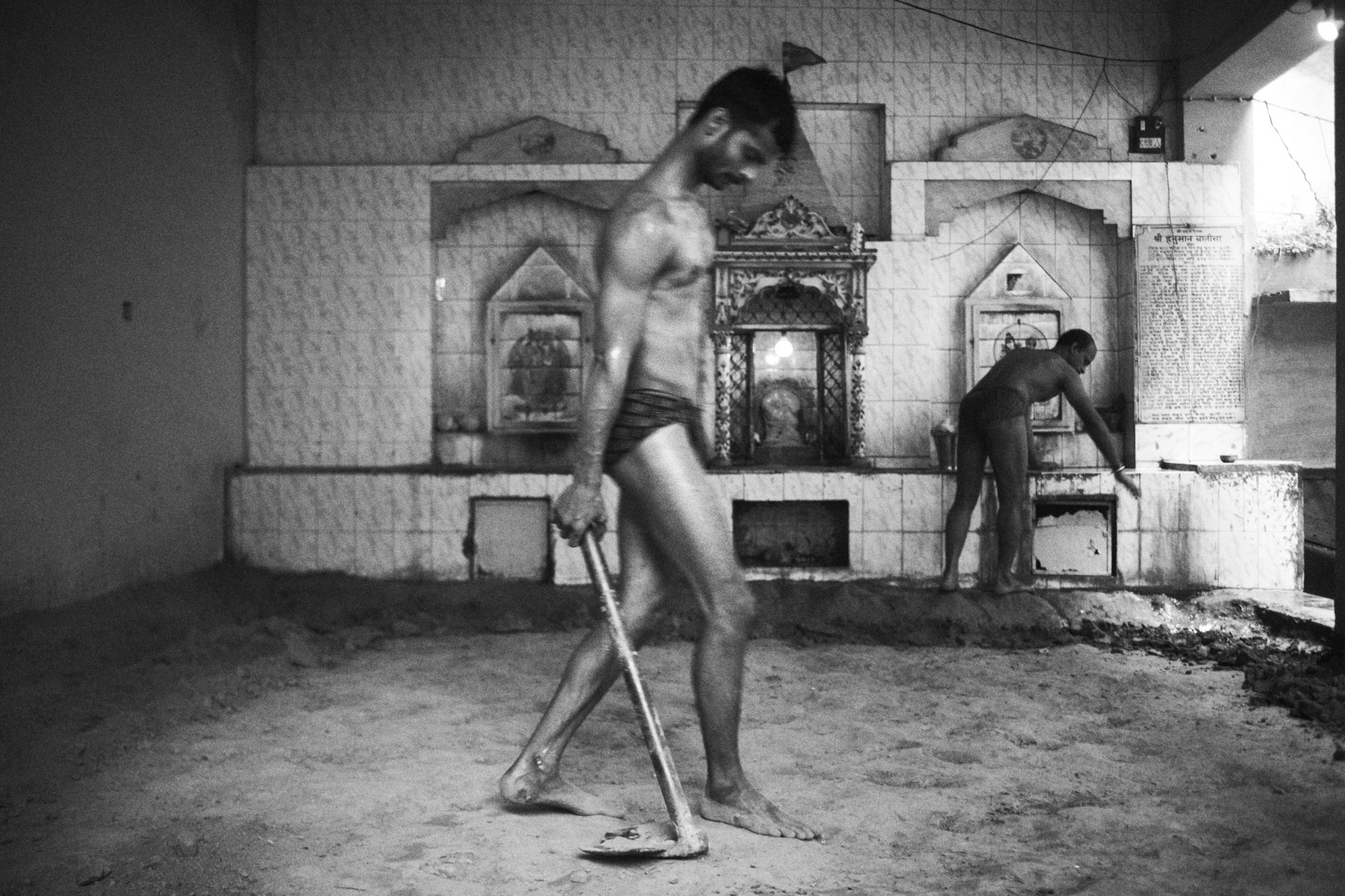 a man evens the floor of a wrestling ring