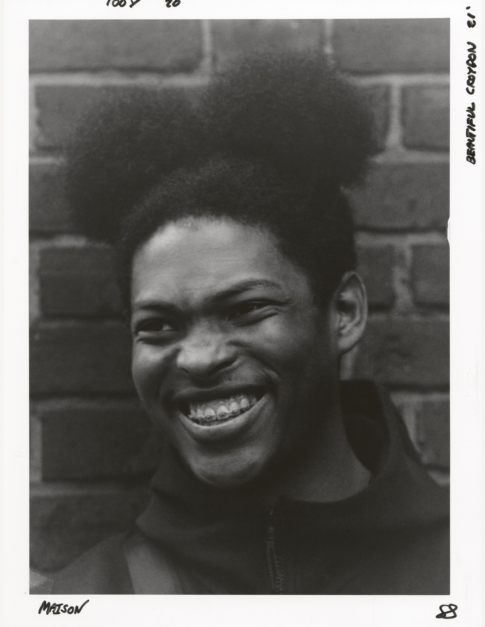 a young man with braces and hair tied into two buns