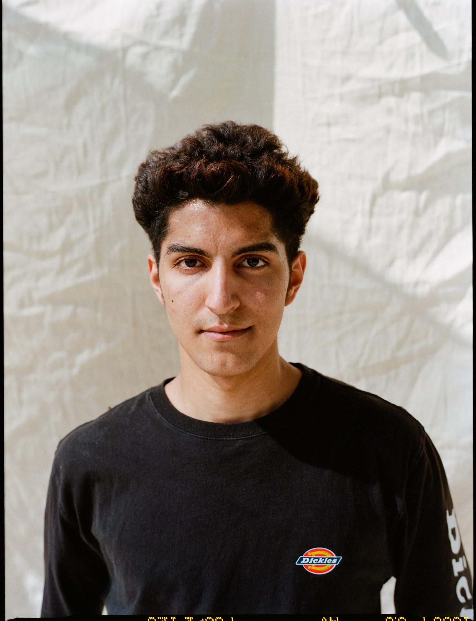 a portrait of a skateboarder wearing a dickies t-shirt